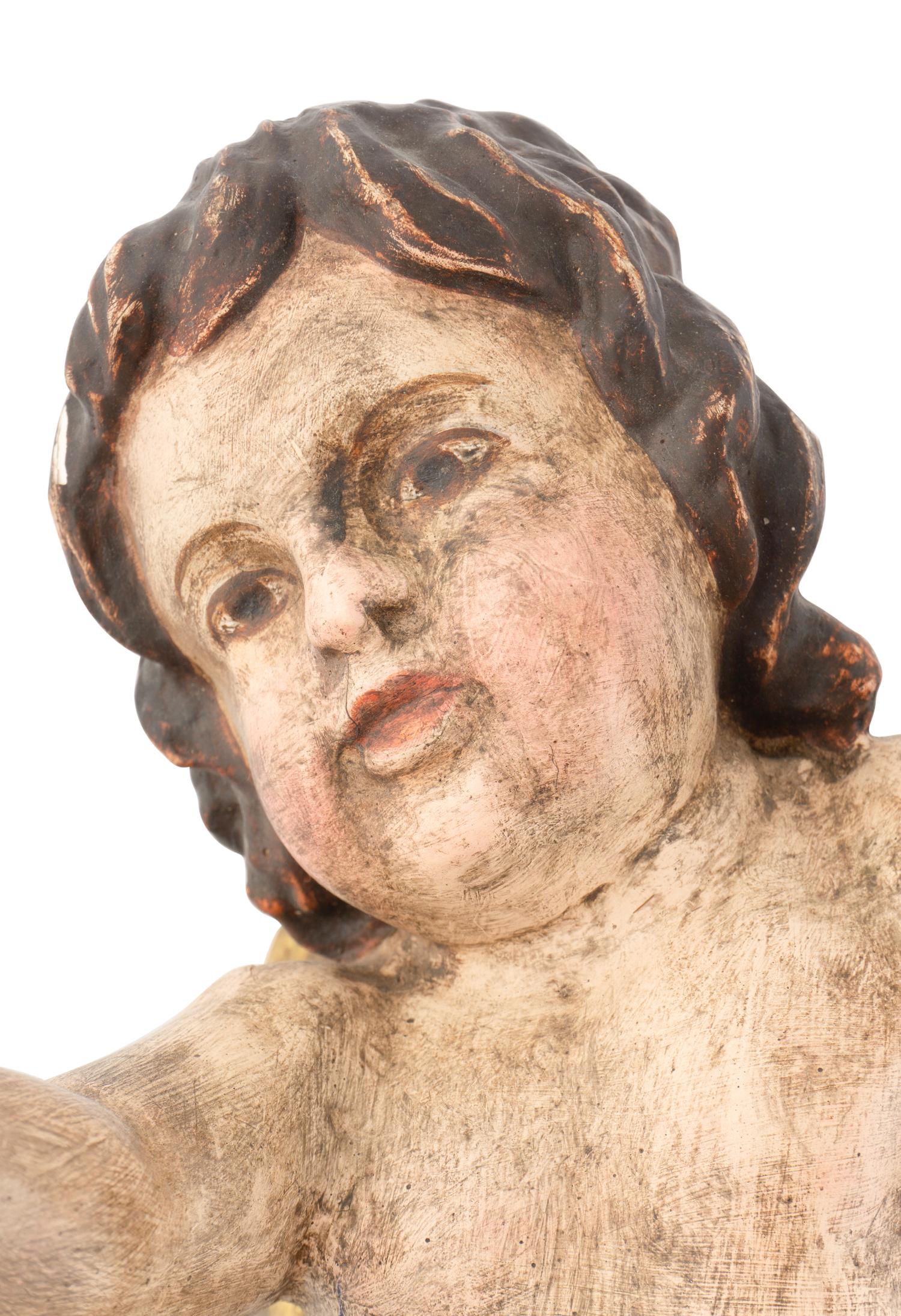 A Pair of Continental Painted and Parcel Gilt Putto Ornaments