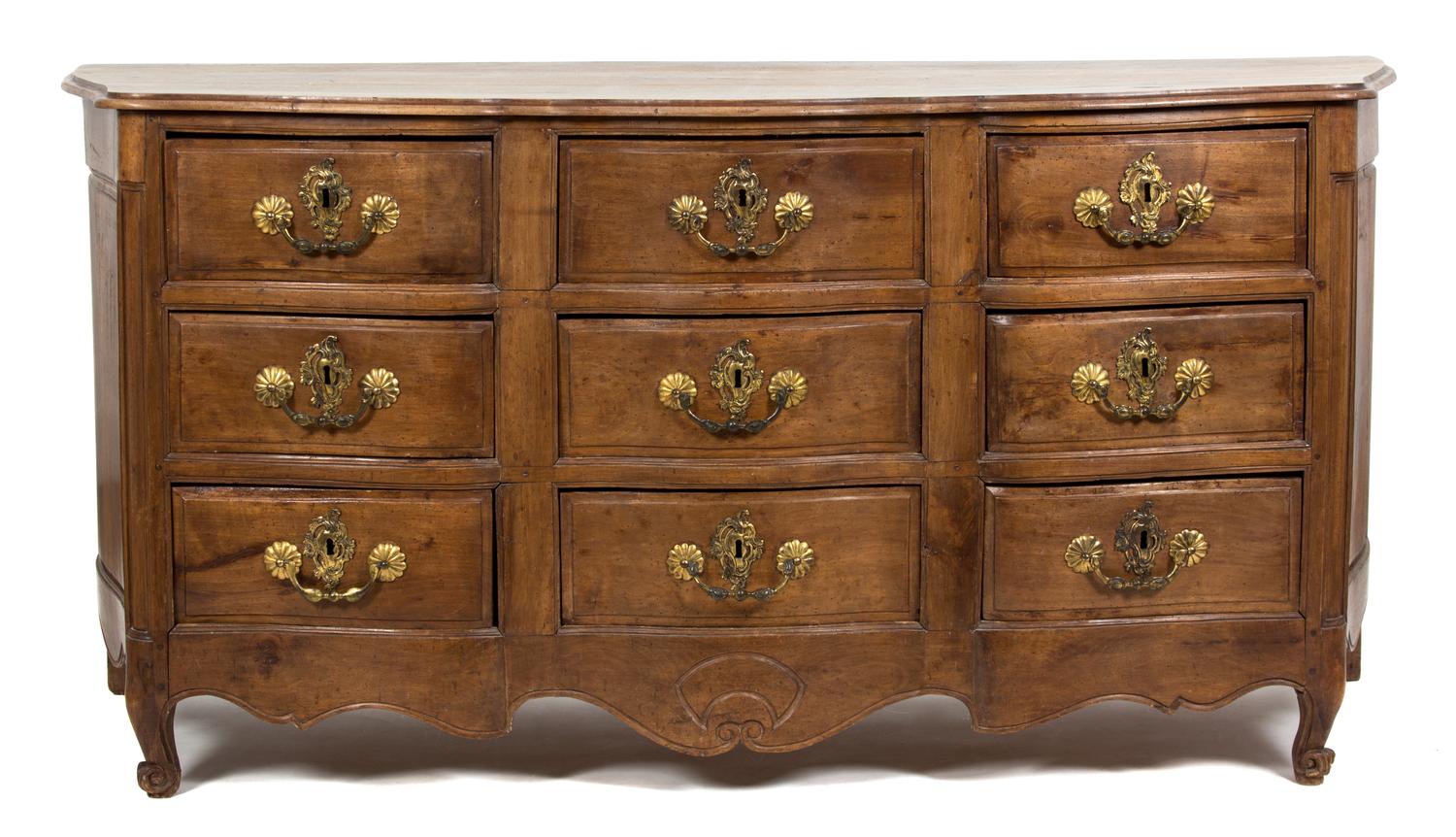 A Louis XV Provincial Style Carved Walnut Nine Drawer Serpentine Commode — 19TH/20TH CENTURY
