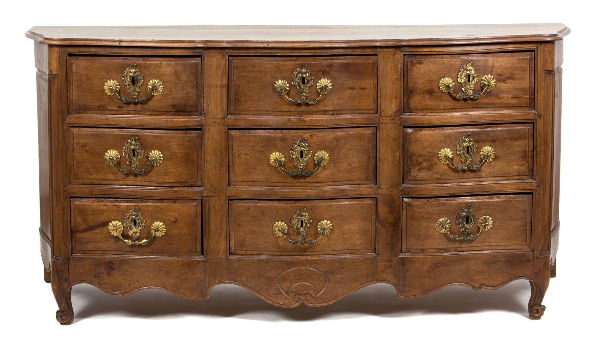 A Louis XV Provincial Style Carved Walnut Nine Drawer Serpentine Commode — 19TH/20TH CENTURY
