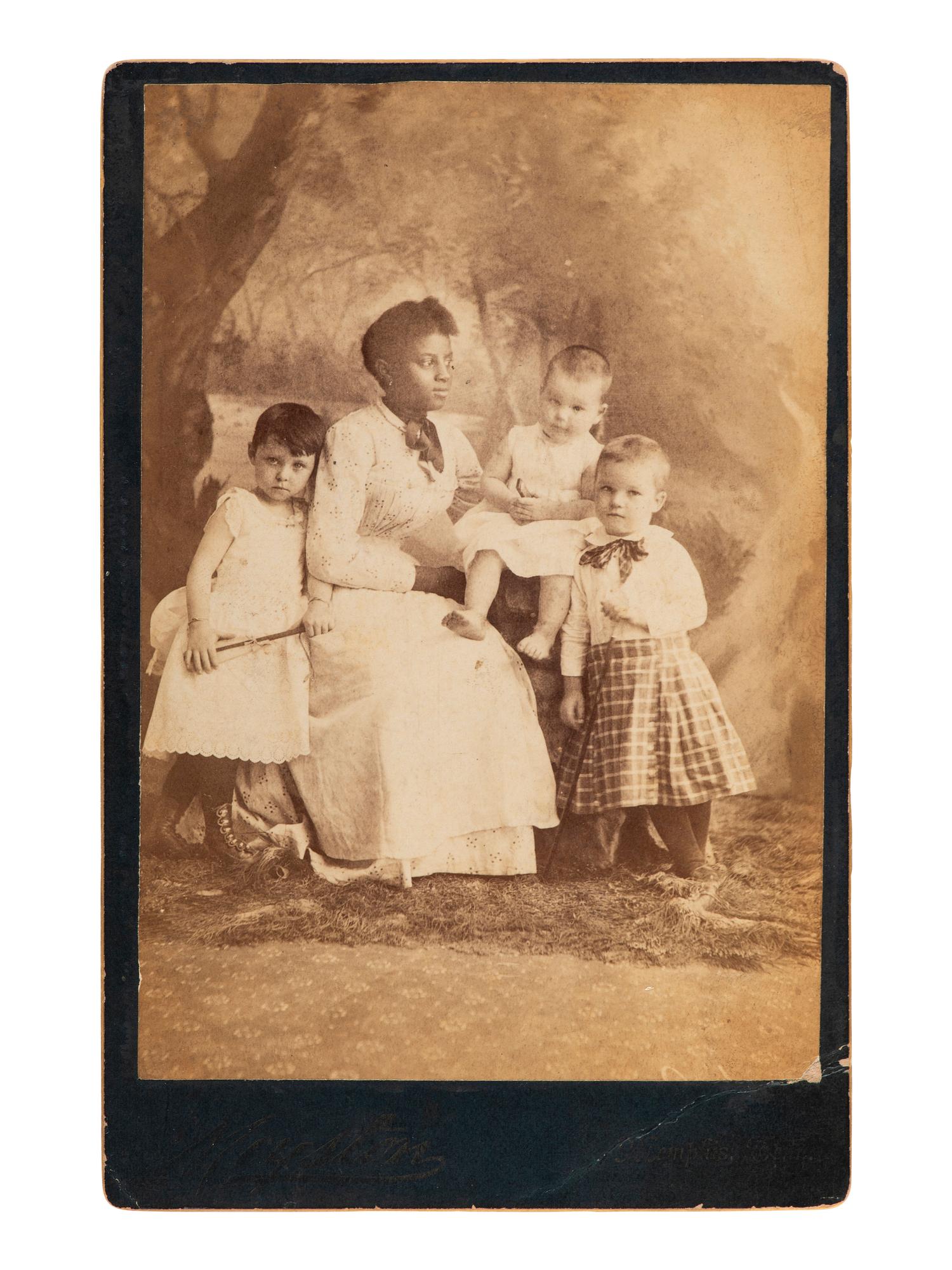 [AFRICAN AMERICANA]. Cabinet card of African American woman posed with white children. Memphis, TN.