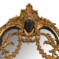 A Baroque Style Part Ebonized Giltwood and Gesso Mirror