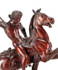 A Carved Wood Figural Group of a Young Man on Horseback Slaying a Lion