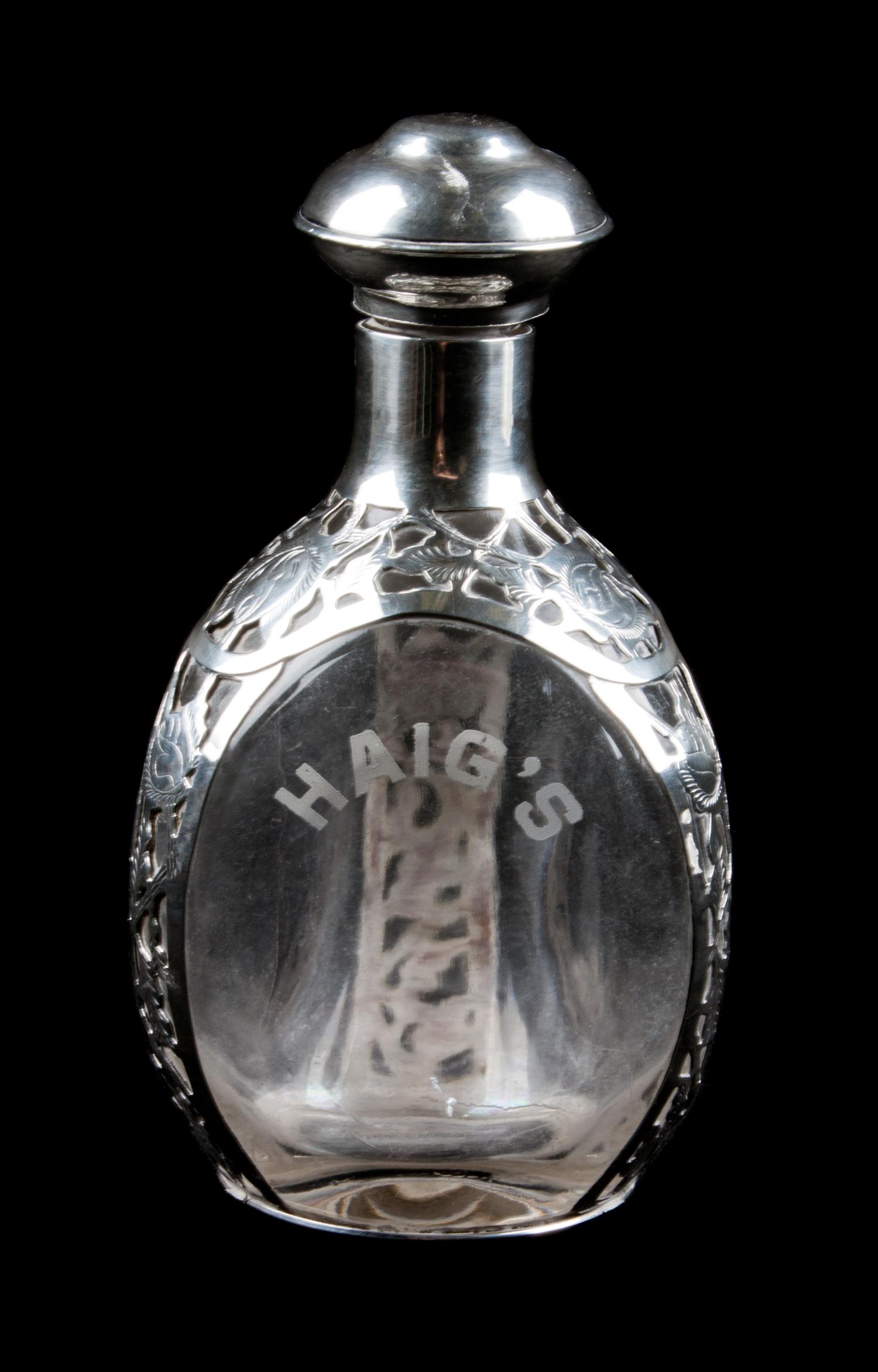 A Mexican Silver Mounted Glass Decanter, , the silver with open overlay work, the bottle etched for Haig whisky.