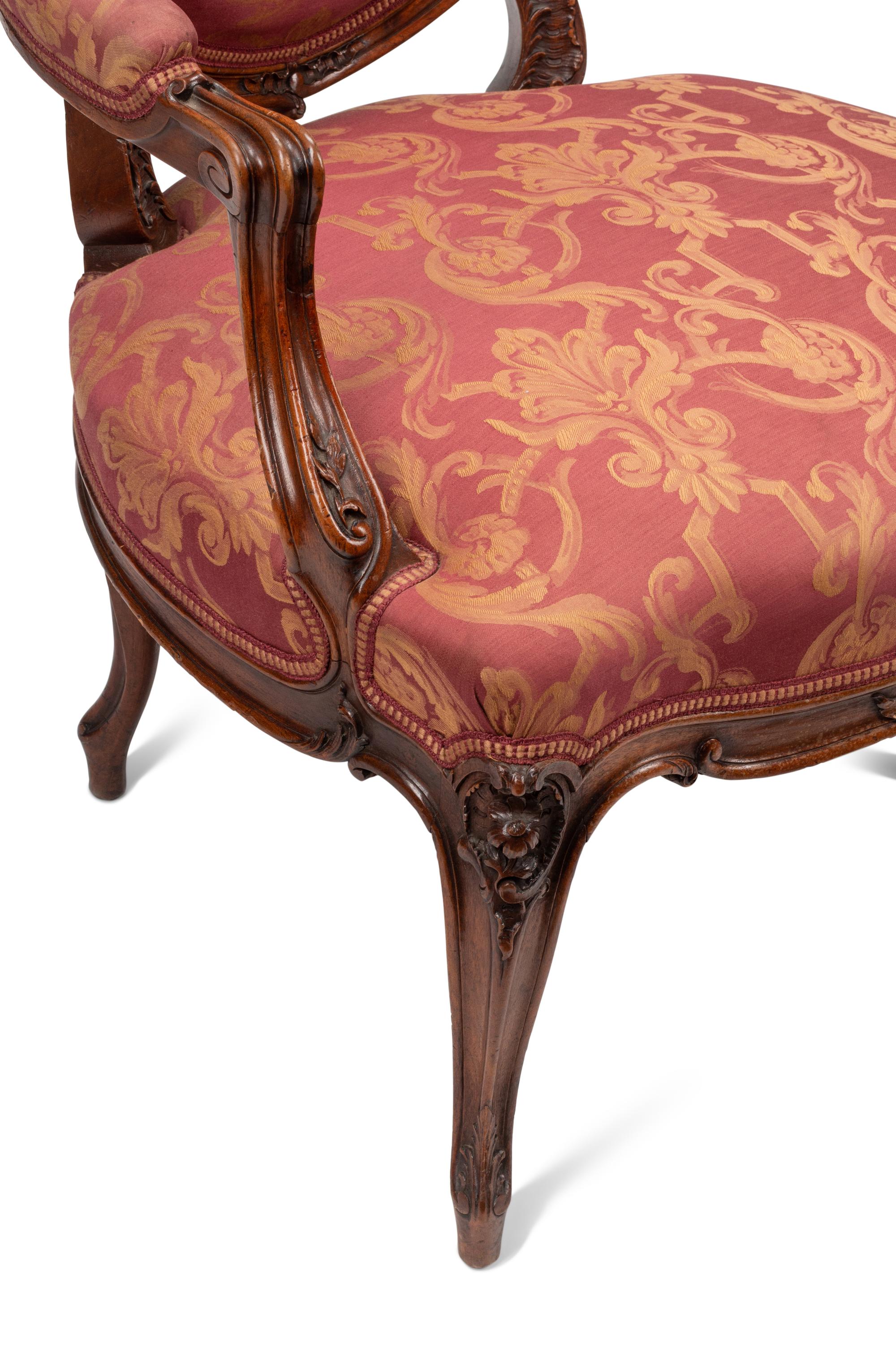 A Pair of Louis XV Style Carved Walnut Fauteuils