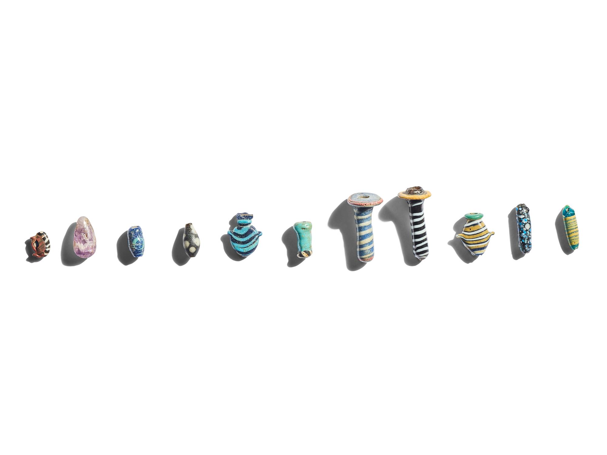 A Group of Eleven Glass Amulets and Ear Studs