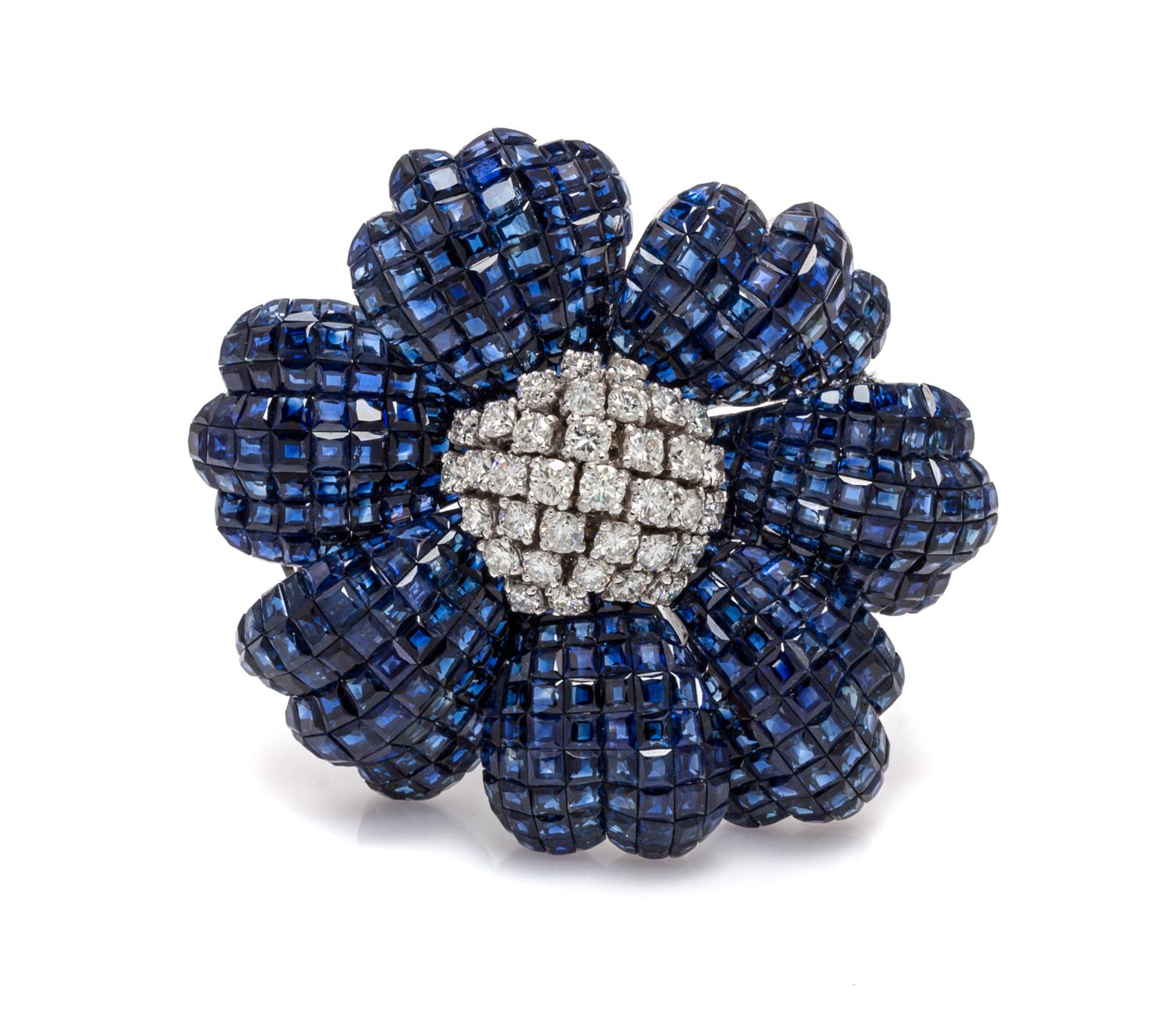 An 18 Karat White Gold, Invisibly Set Sapphire and Diamond Flower Brooch, 35.00 dwts.