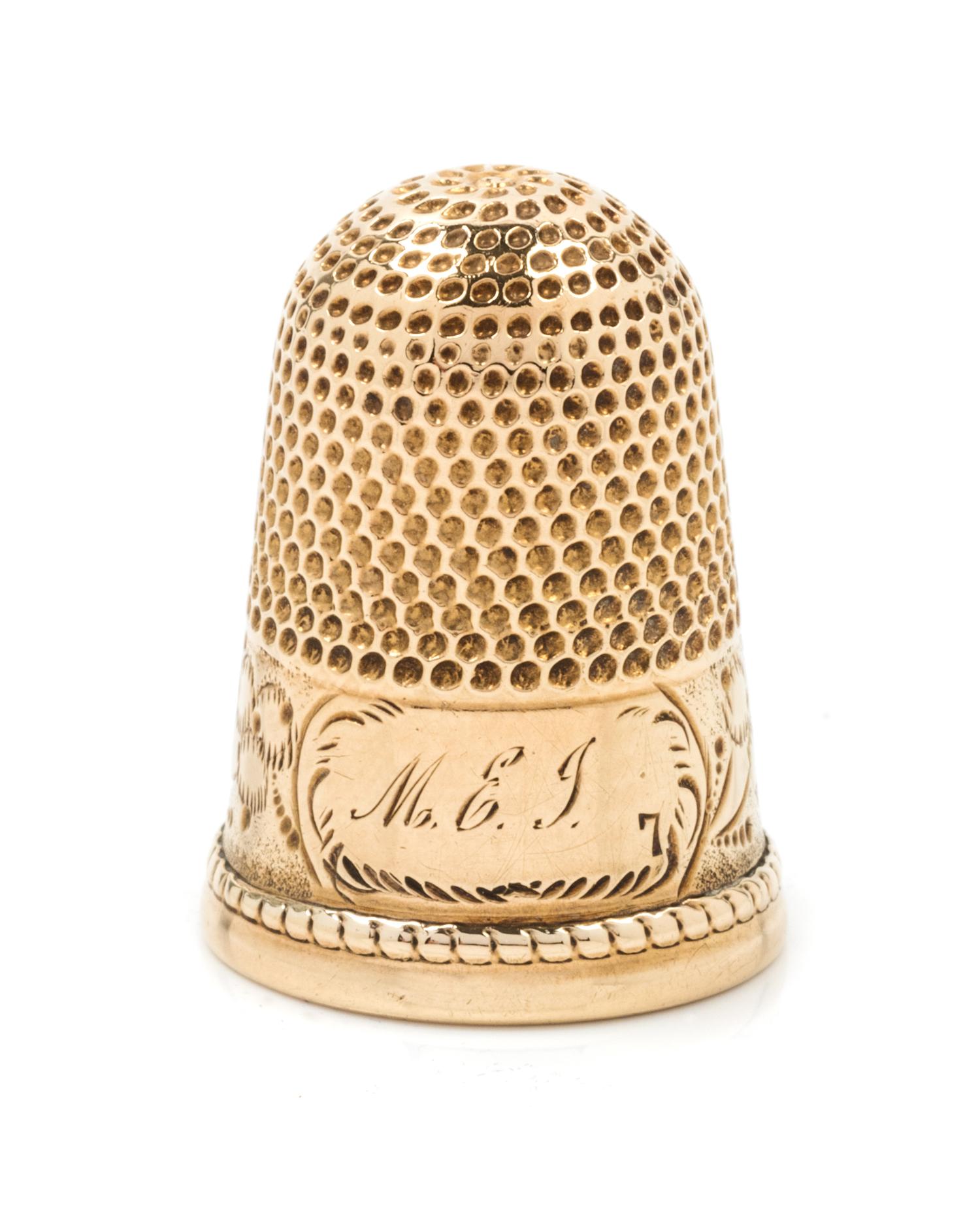 A Yellow Gold Thimble, Possibly American, the knurled top and body above an engraved floral and foliate band bearing an engraved monogr