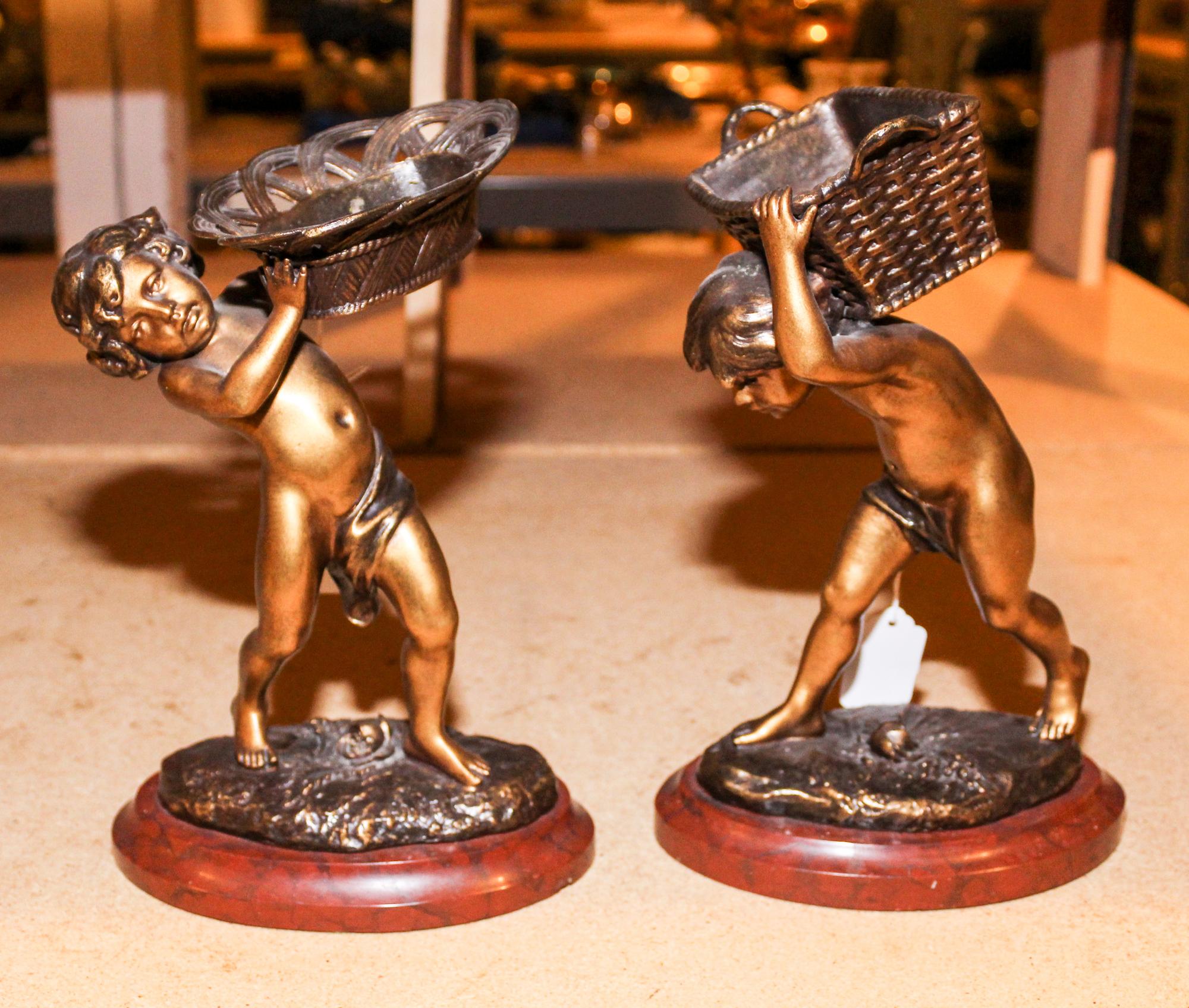 A Pair of French Cast Metal Models of Young Basket Merchants Height of taller 10 1/4 inches.