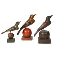Three carved and painted birds on spherical stands in the manner of Schnockschnitzler Simmons (active 1895-1910) Robert Stauffer, late 20th century