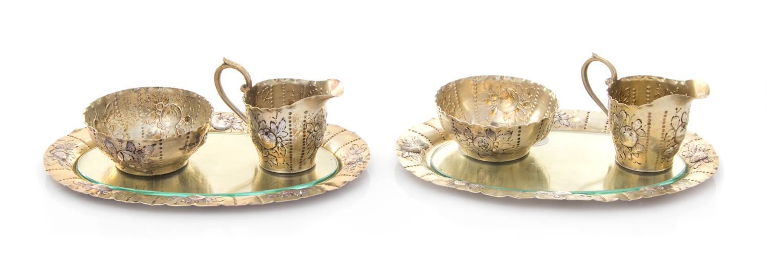 A Pair of German Silver-Gilt Creamer and Sugar Sets, , comprising a creamer, sugar and underplate, each having floral and foliate repou