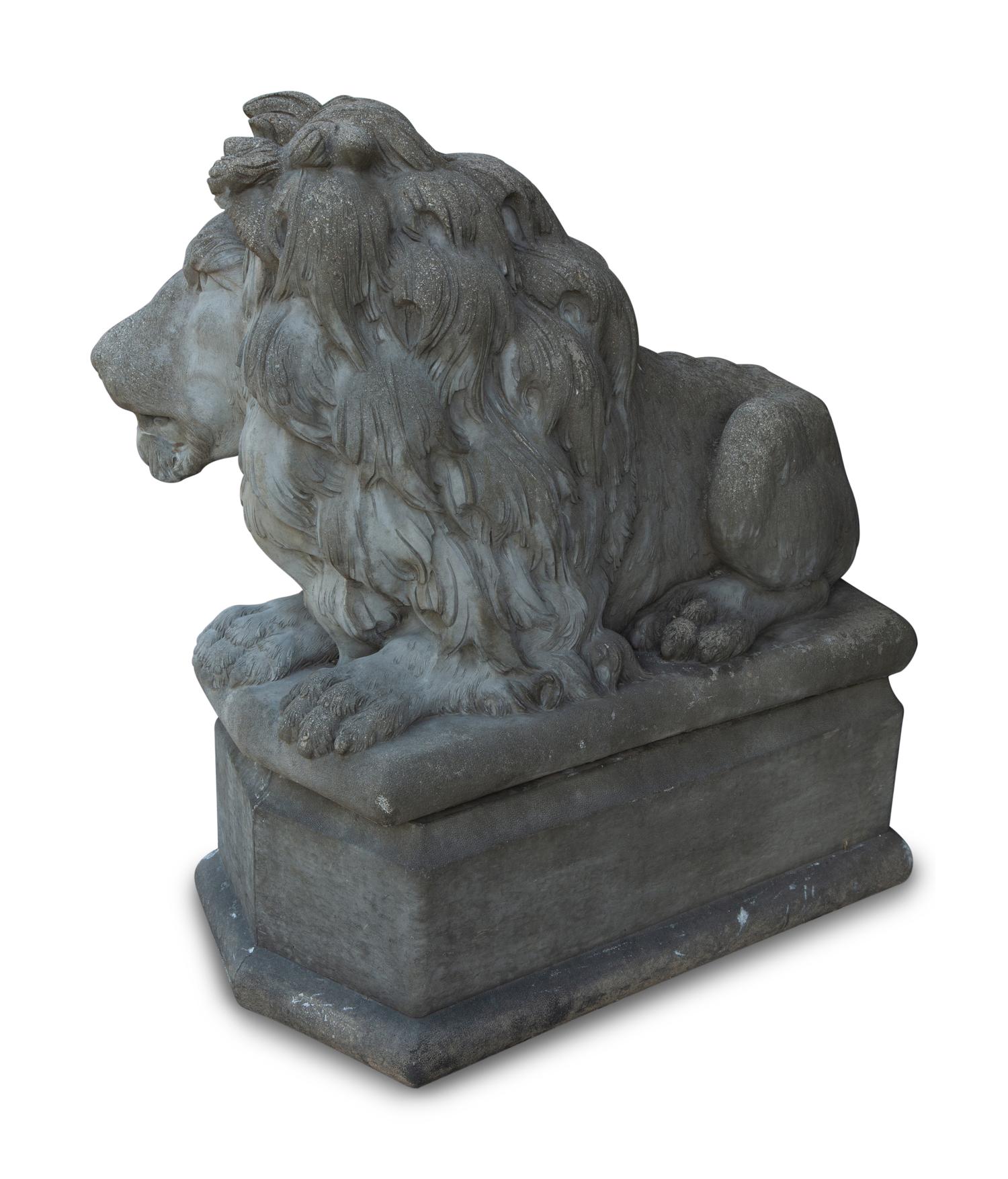 A Pair of Cast Stone Recumbent Lions on Pedestal Bases