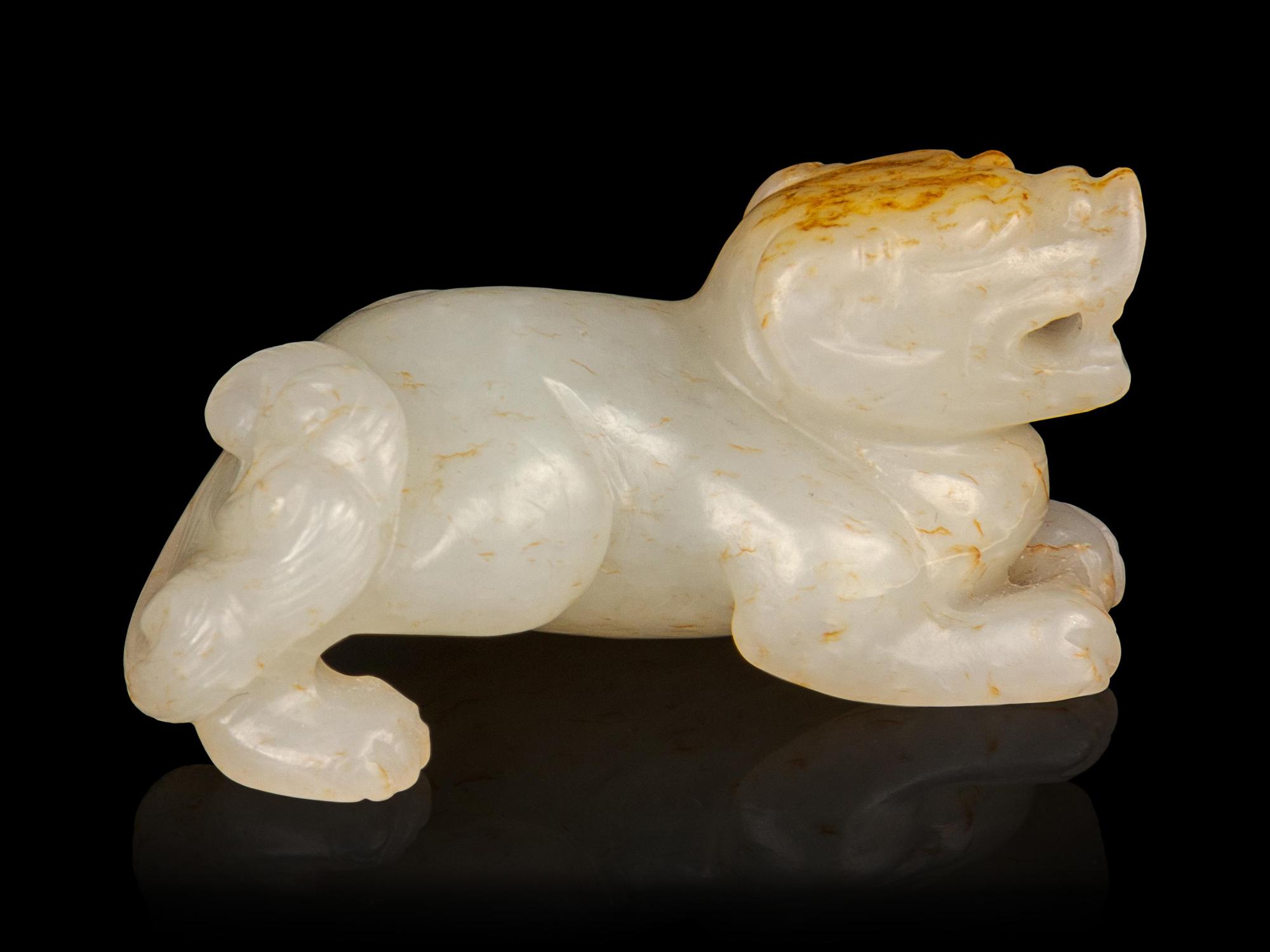A Russet and White Jade Figure of a Recumbent Beast