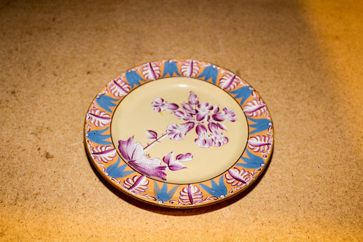 A Polychrome Decorated Stoneware Plate Diameter of larger 8 1/4 inches.