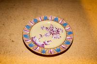 A Polychrome Decorated Stoneware Plate Diameter of larger 8 1/4 inches.