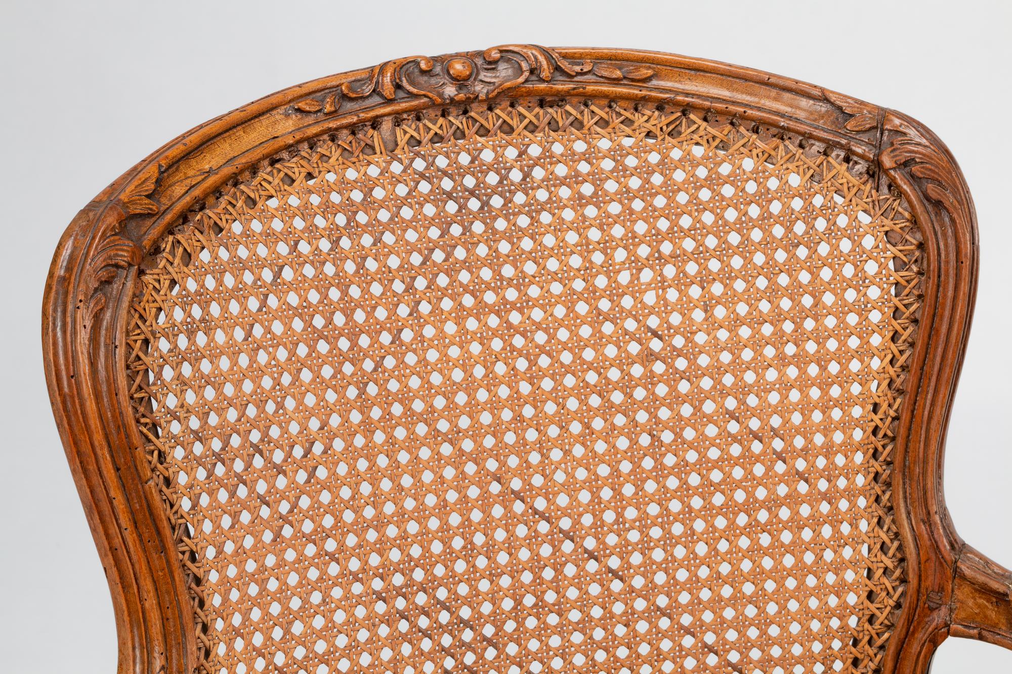 A Pair of Louis XV Beechwood Fauteuils with Cane and Leather Seat Cushions