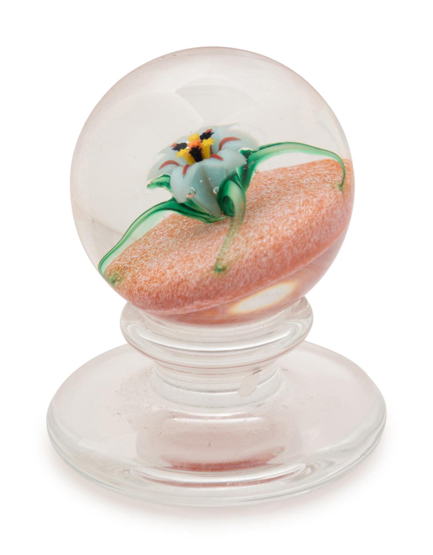 A Charles Kaziun Jr. White Spider Lily on Orange Ground Miniature Tilted Pedestal Glass Paperweight