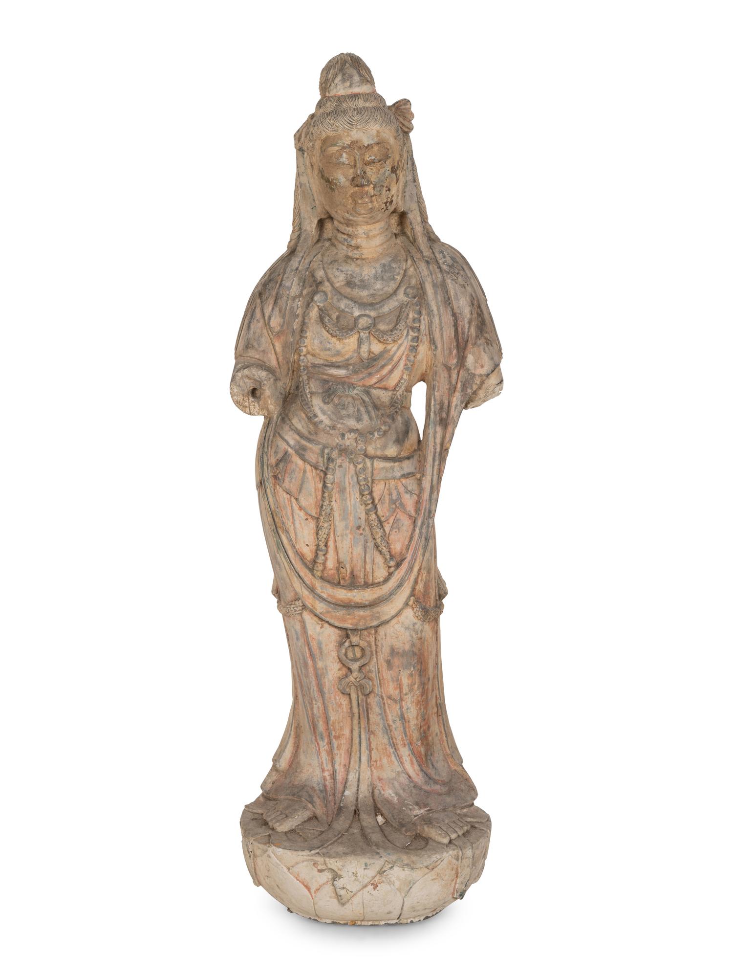A Chinese Carved Stone Standing Guanyin Figure with Remnants of Polychrome Decoration