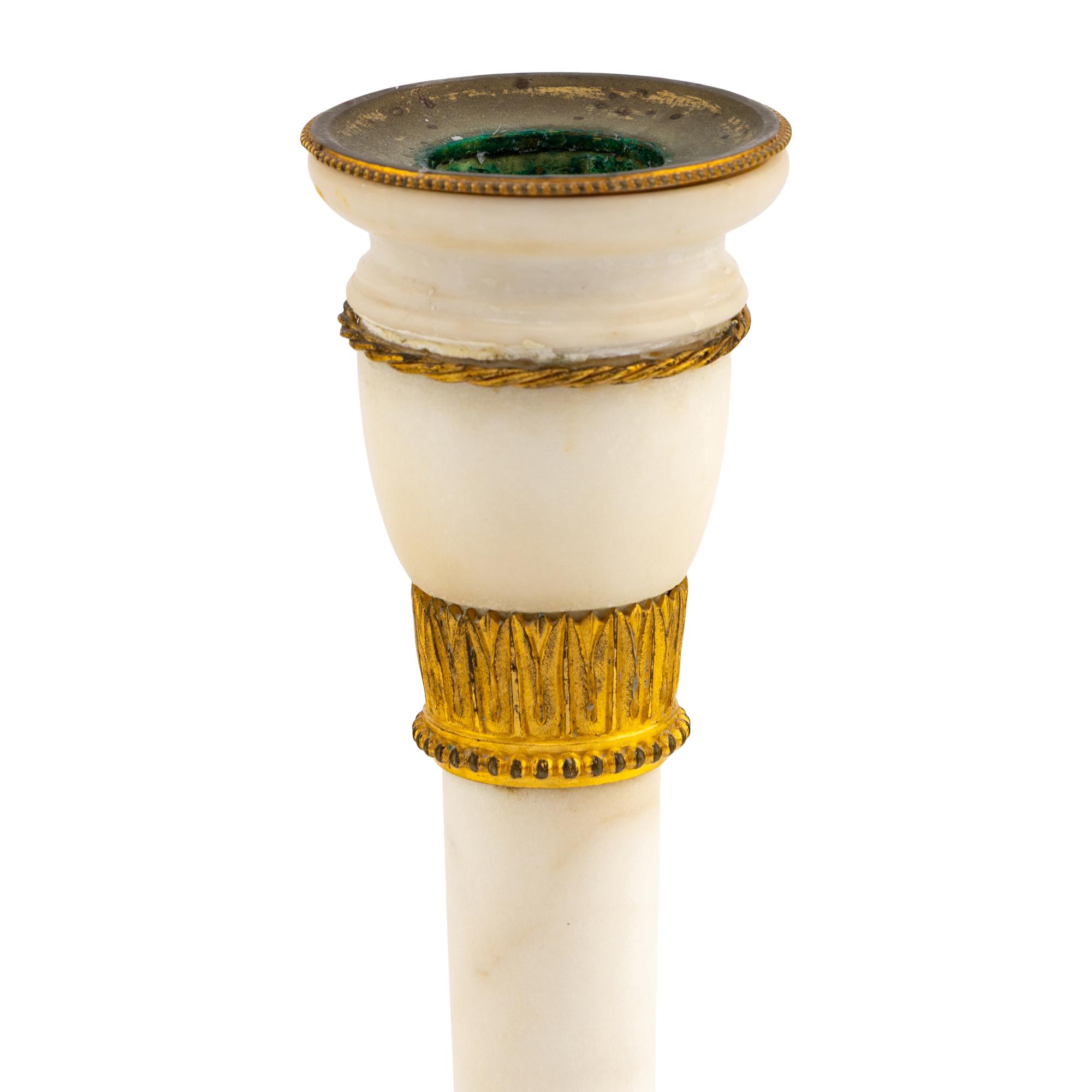 A Pair of Directoire Gilt Bronze and White Marble Candlesticks