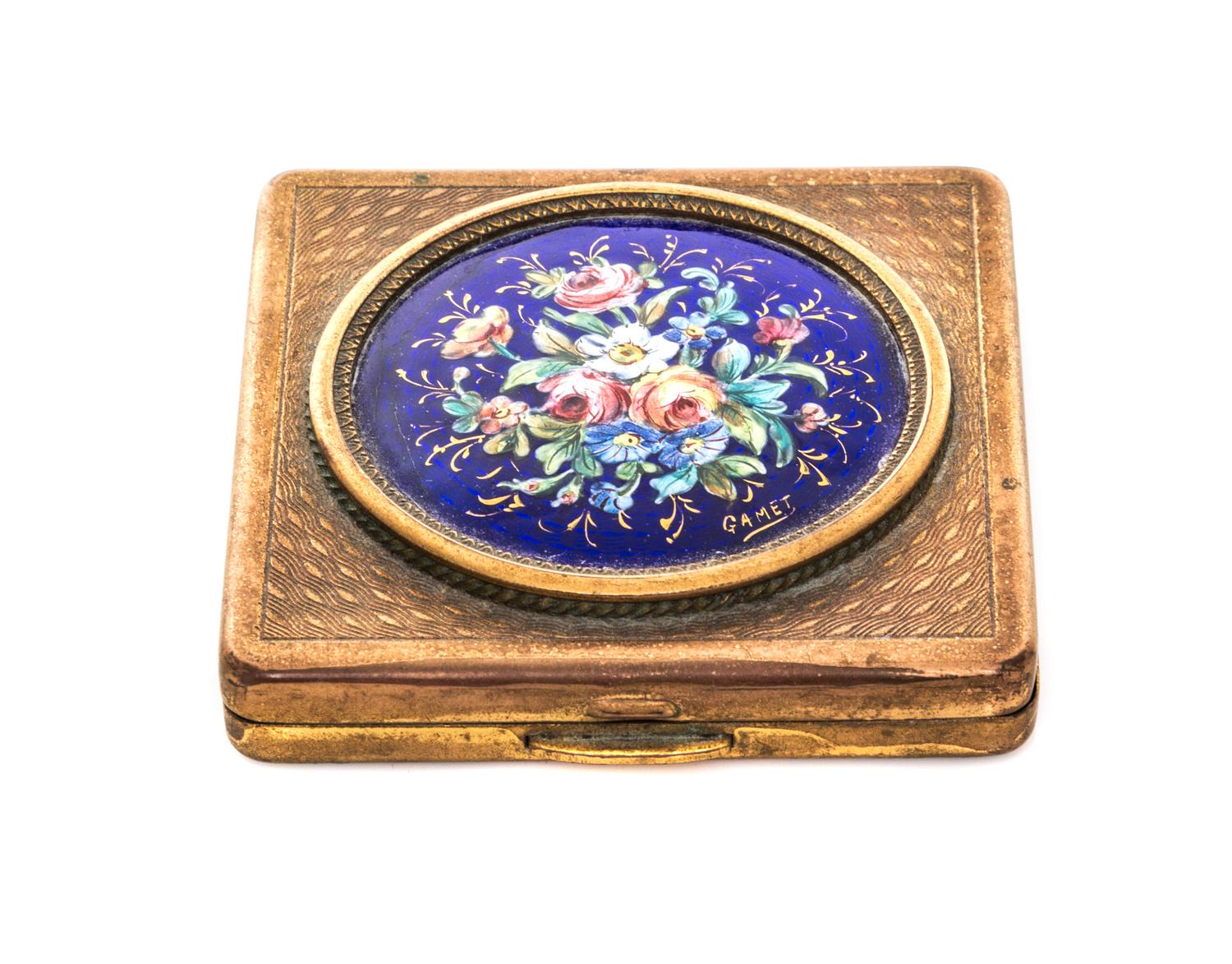 A French Enameled Gilt Metal Compact, 20th Century, of square form, the hinged lid decorated with a round enameled plaque depicting a p