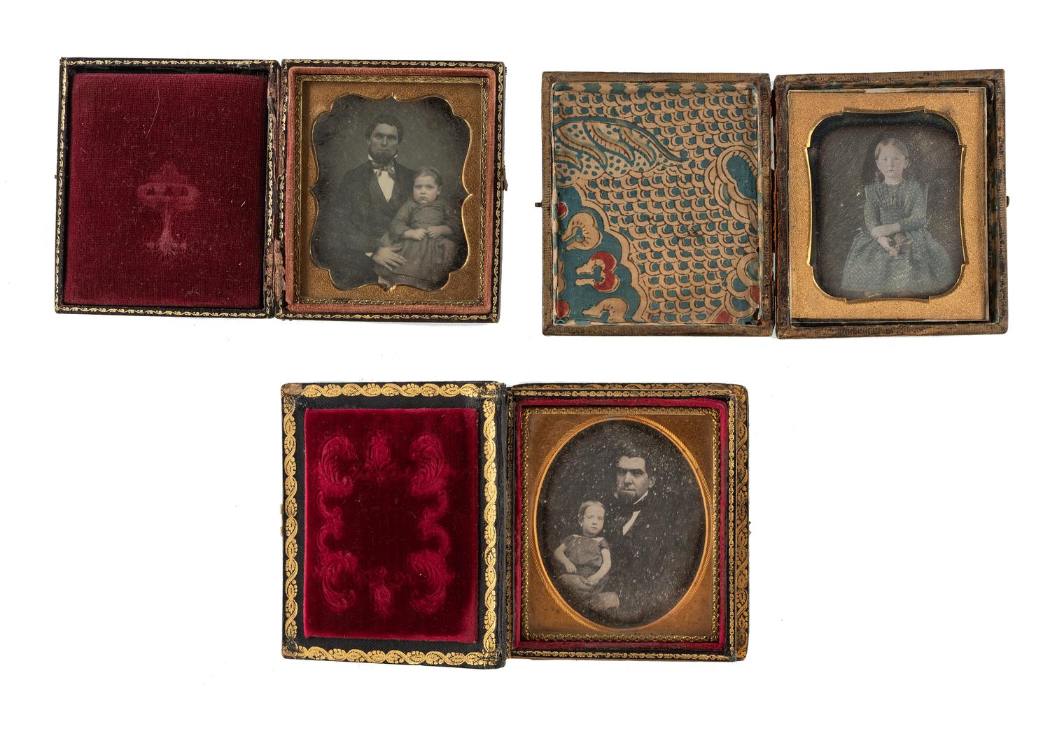 [EARLY PHOTOGRAPHY - PORTRAITURE]. A pair of daguerreotypes featuring a father holding his daughter on his lap, with hand painted and other cases, including: