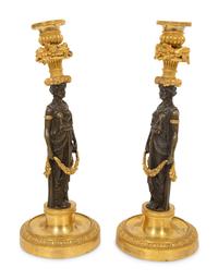 A Pair of French Gilt and Patinated Bronze Figural Candlesticks