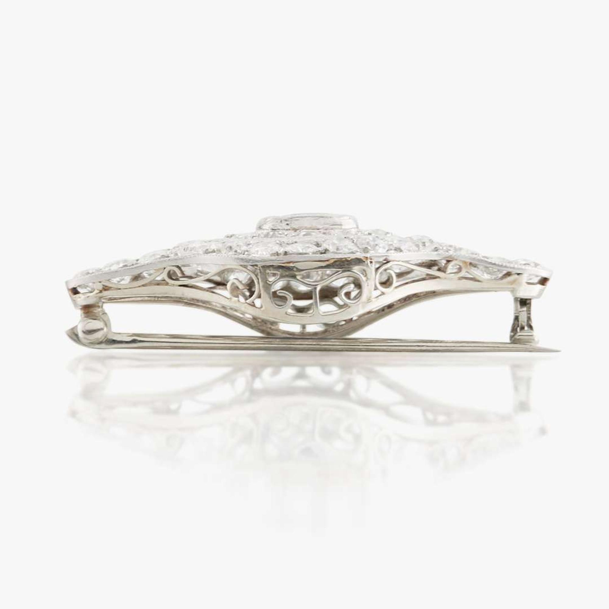 A sapphire, diamond, platinum, and white metal brooch