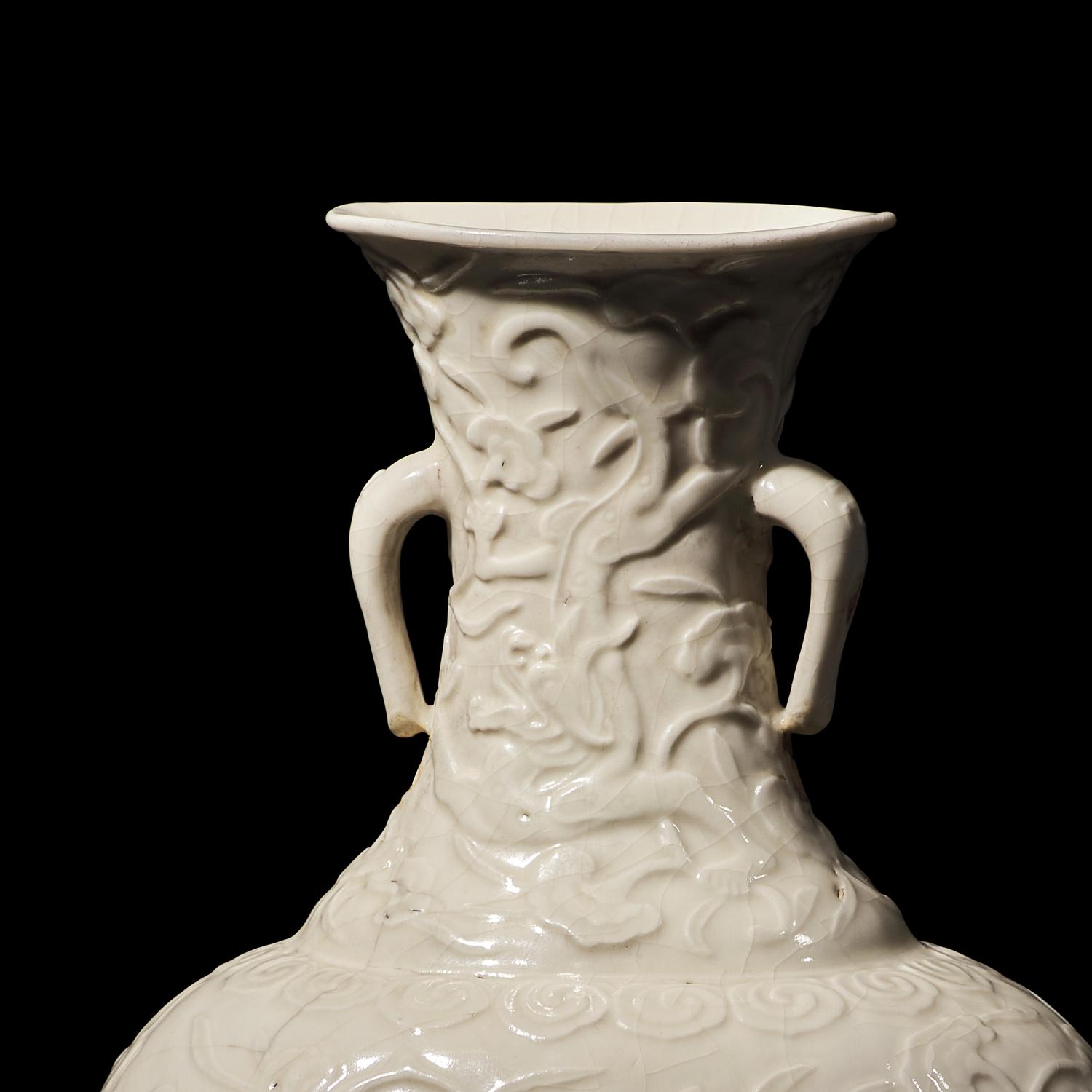 A Chinese White Glazed Soft Paste Molded 'Dragons and Lingzhi' Vase, 18th Century 清中期 白釉模印漿胎靈芝螭龍紋瓶