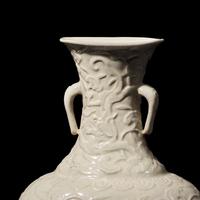 A Chinese White Glazed Soft Paste Molded 'Dragons and Lingzhi' Vase, 18th Century 清中期 白釉模印漿胎靈芝螭龍紋瓶