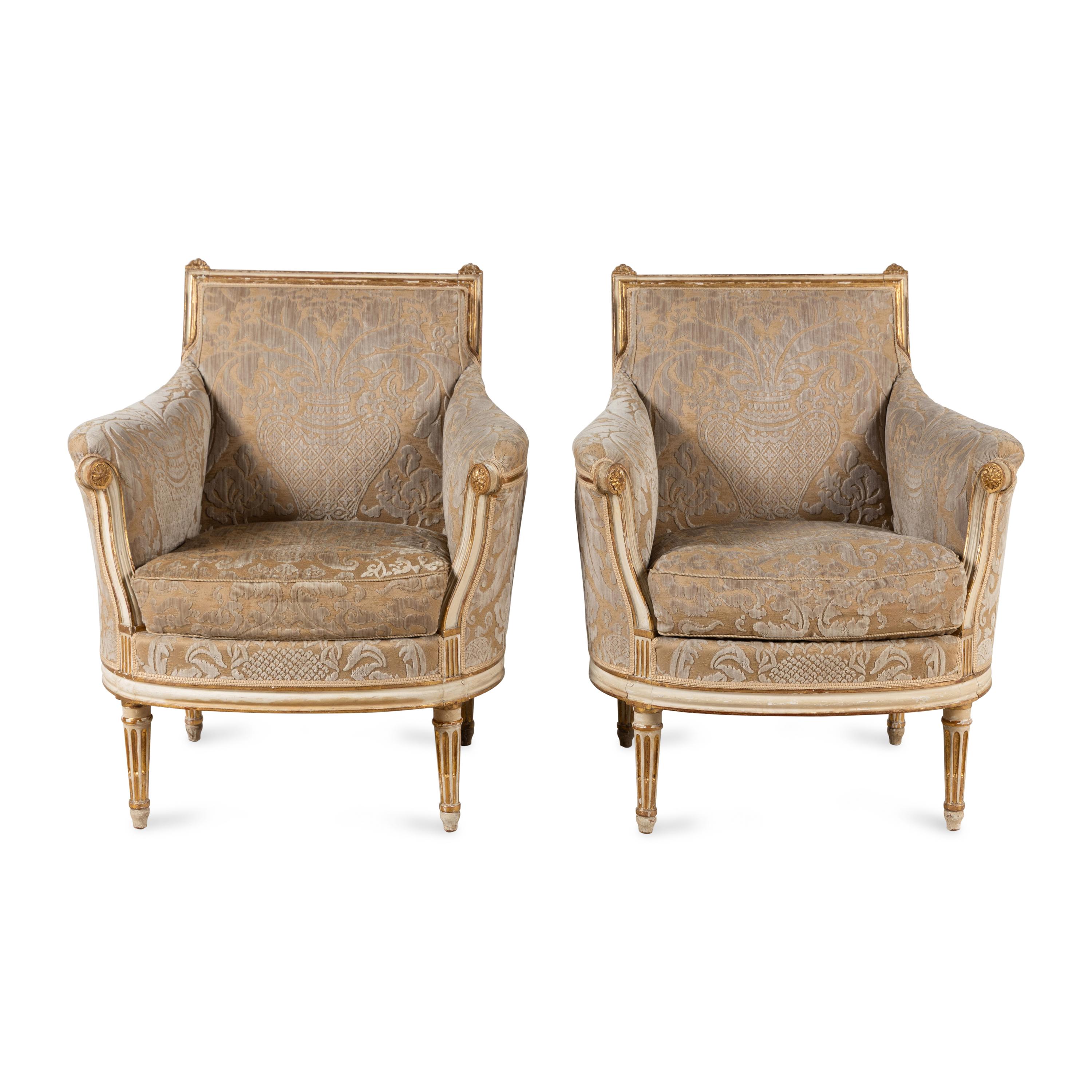 A Pair of Louis XVI Cream-Painted and Parcel Gilt Bergères