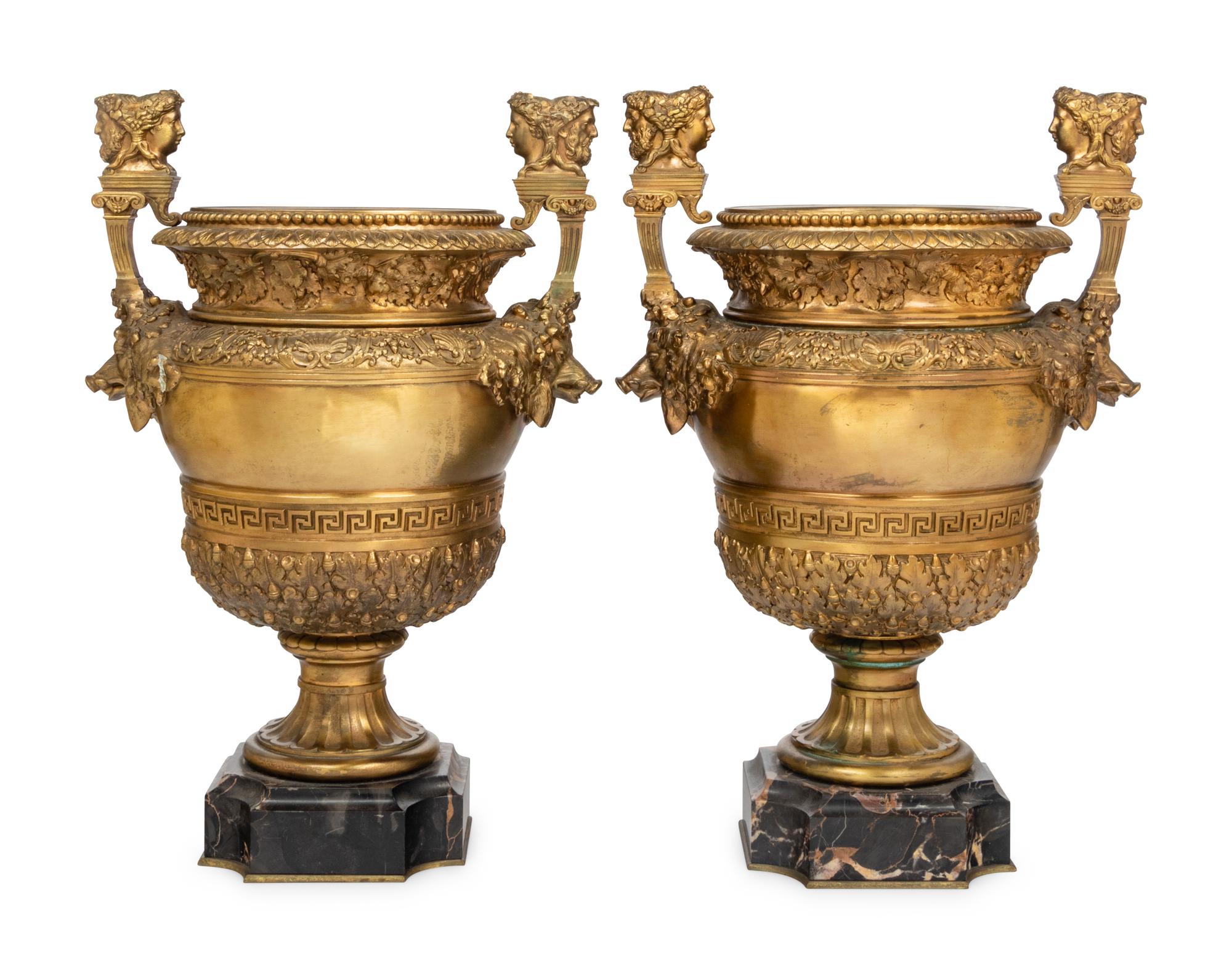 A Pair of Neoclassical Gilt Bronze Urns on Marble Plinths