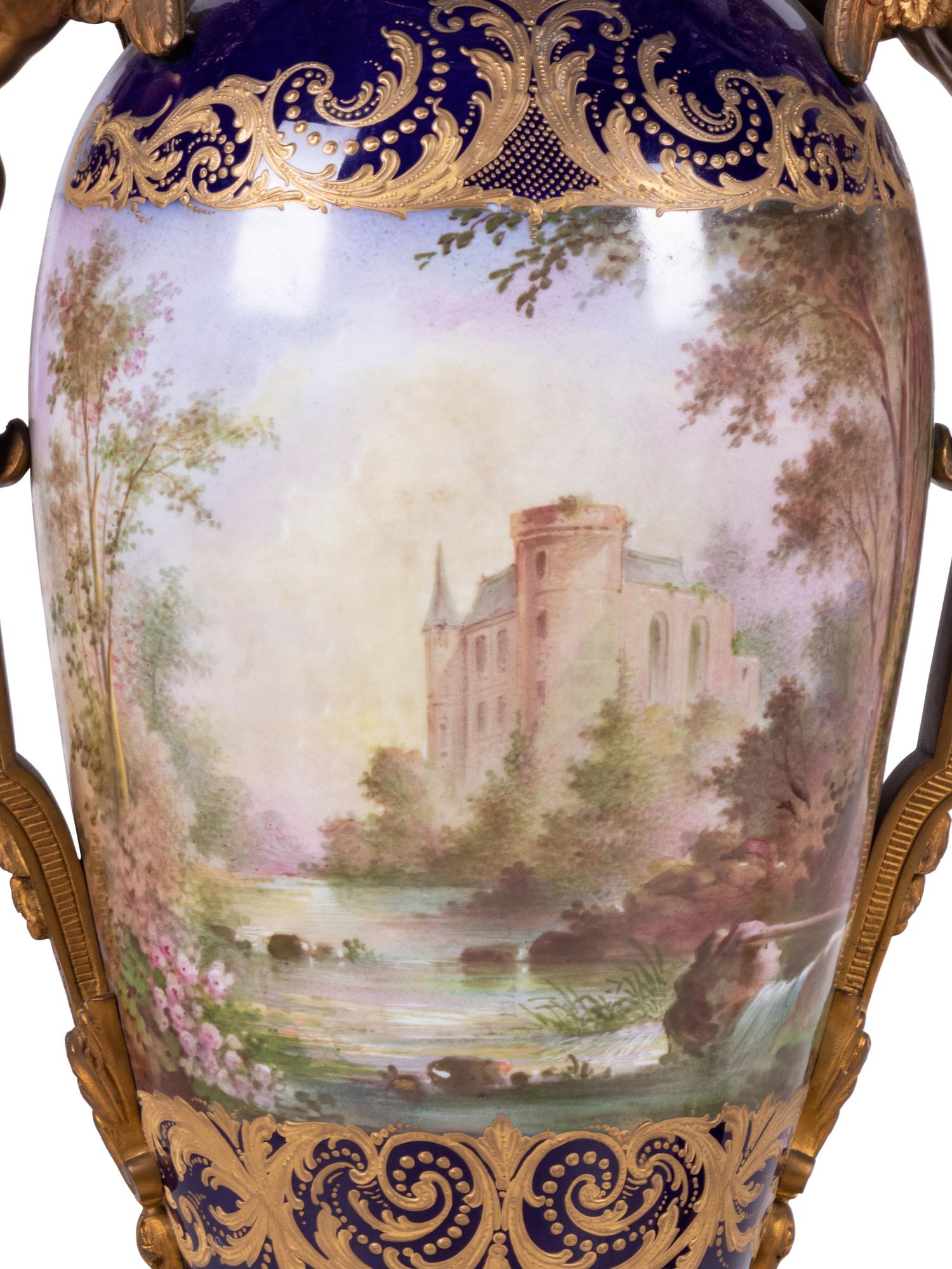 A Pair of Sèvres Style Gilt Bronze Mounted Painted and Parcel Gilt Porcelain Urns