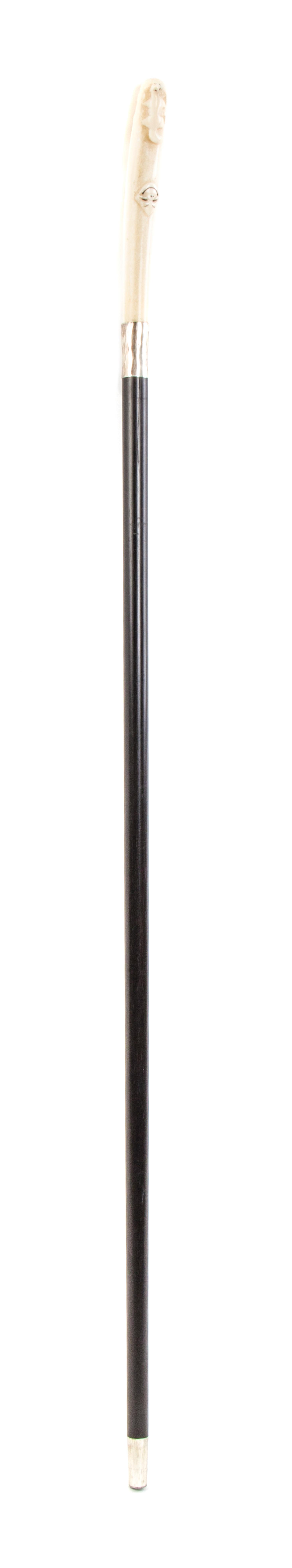 An American Inuit Carved Walrus Ivory Handled Walking Stick, Length of handle 5 3/4 x length overall 34 1/2 inches.