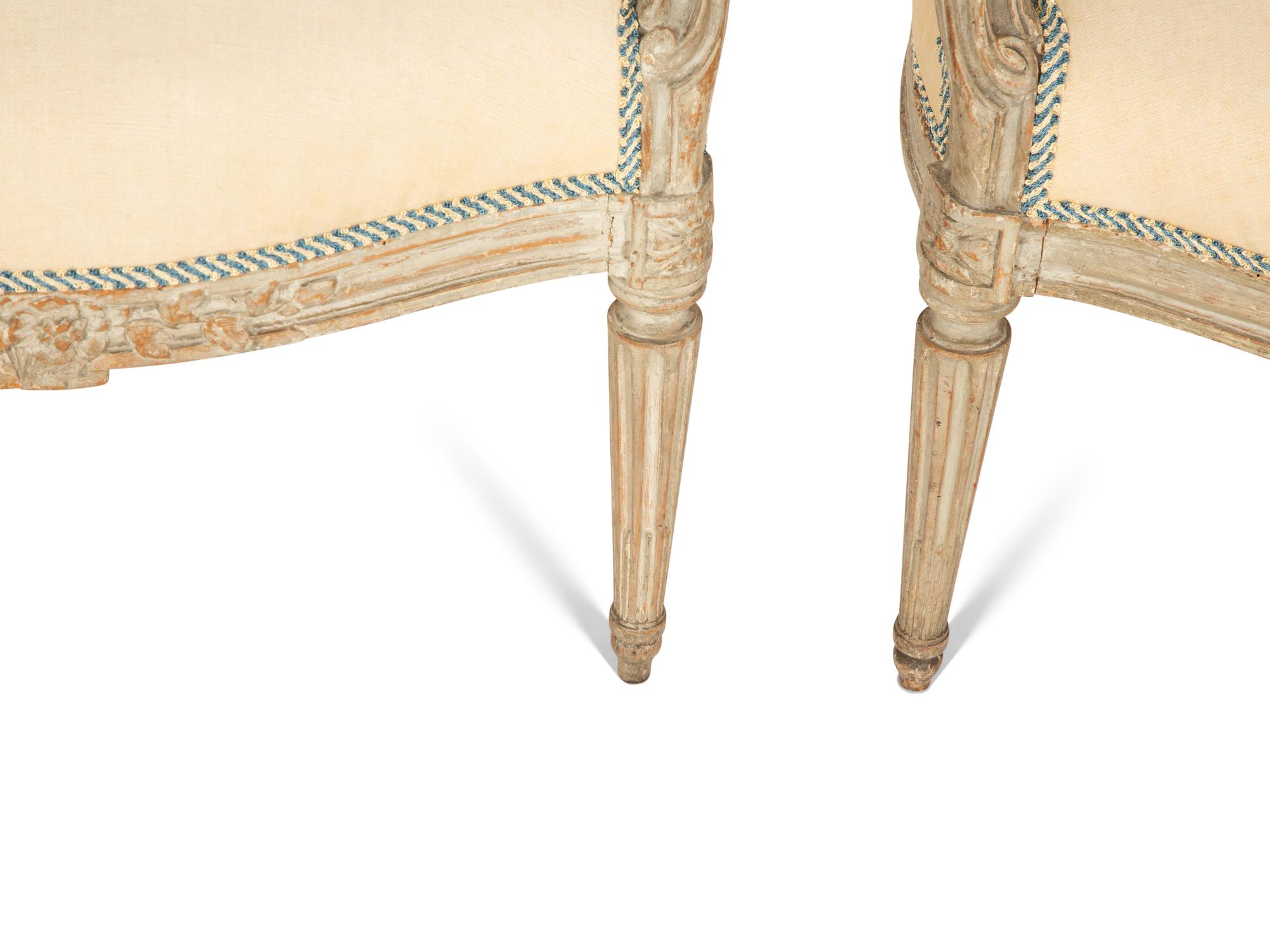 A Set of Four Louis XVI Grey-Painted and Parcel Gilt Fauteuils