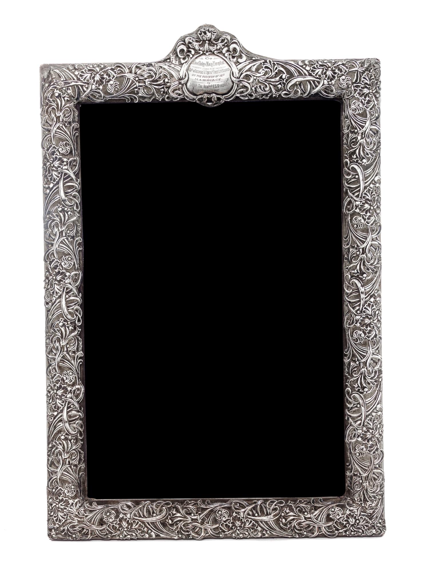 An American Silver Frame, Circa 1900, chased with irises and foliate scrolls and mounted to a fabric-covered back, having an engraved c