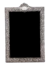 An American Silver Frame, Circa 1900, chased with irises and foliate scrolls and mounted to a fabric-covered back, having an engraved c