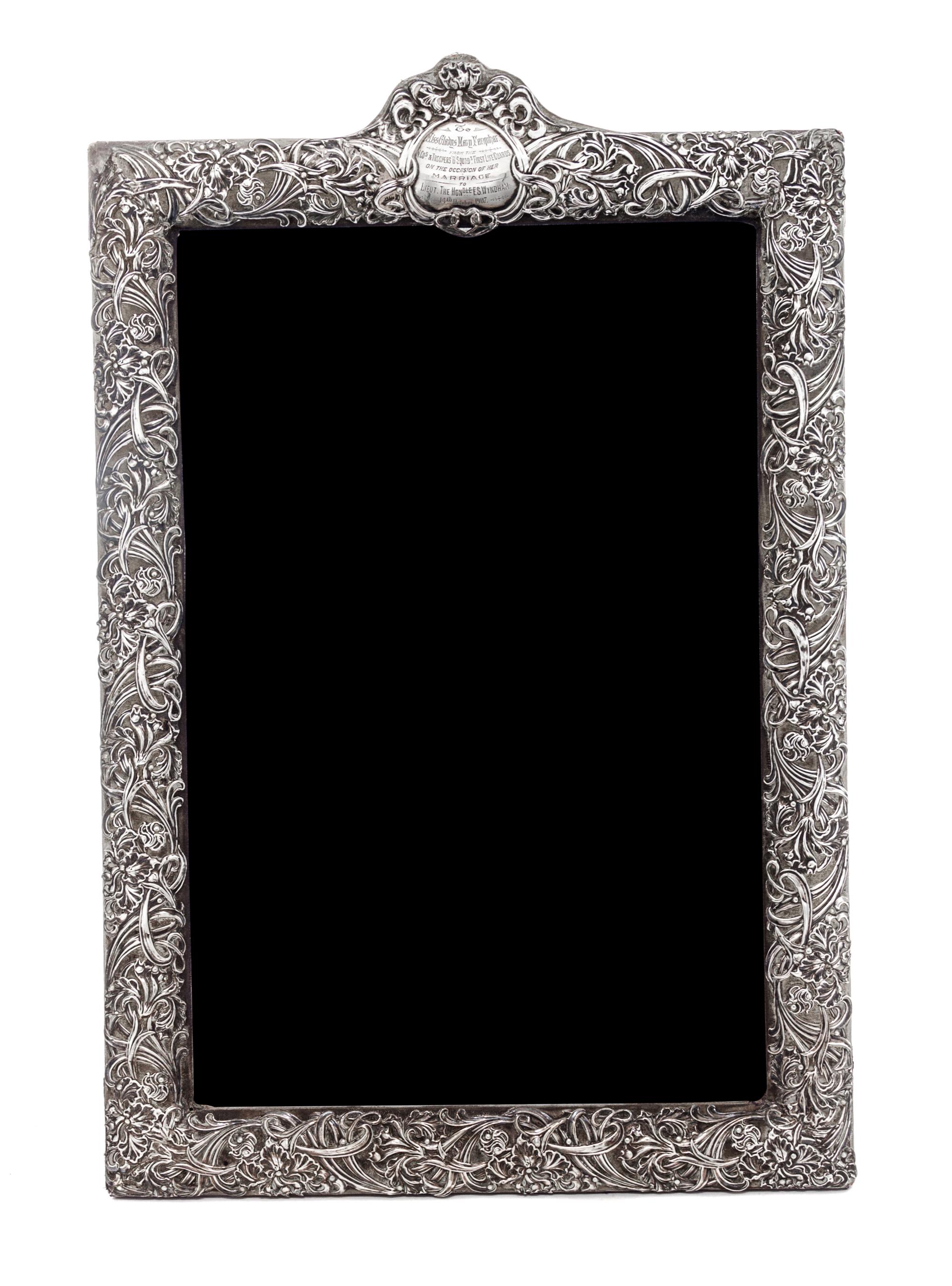 An American Silver Frame, Circa 1900, chased with irises and foliate scrolls and mounted to a fabric-covered back, having an engraved c