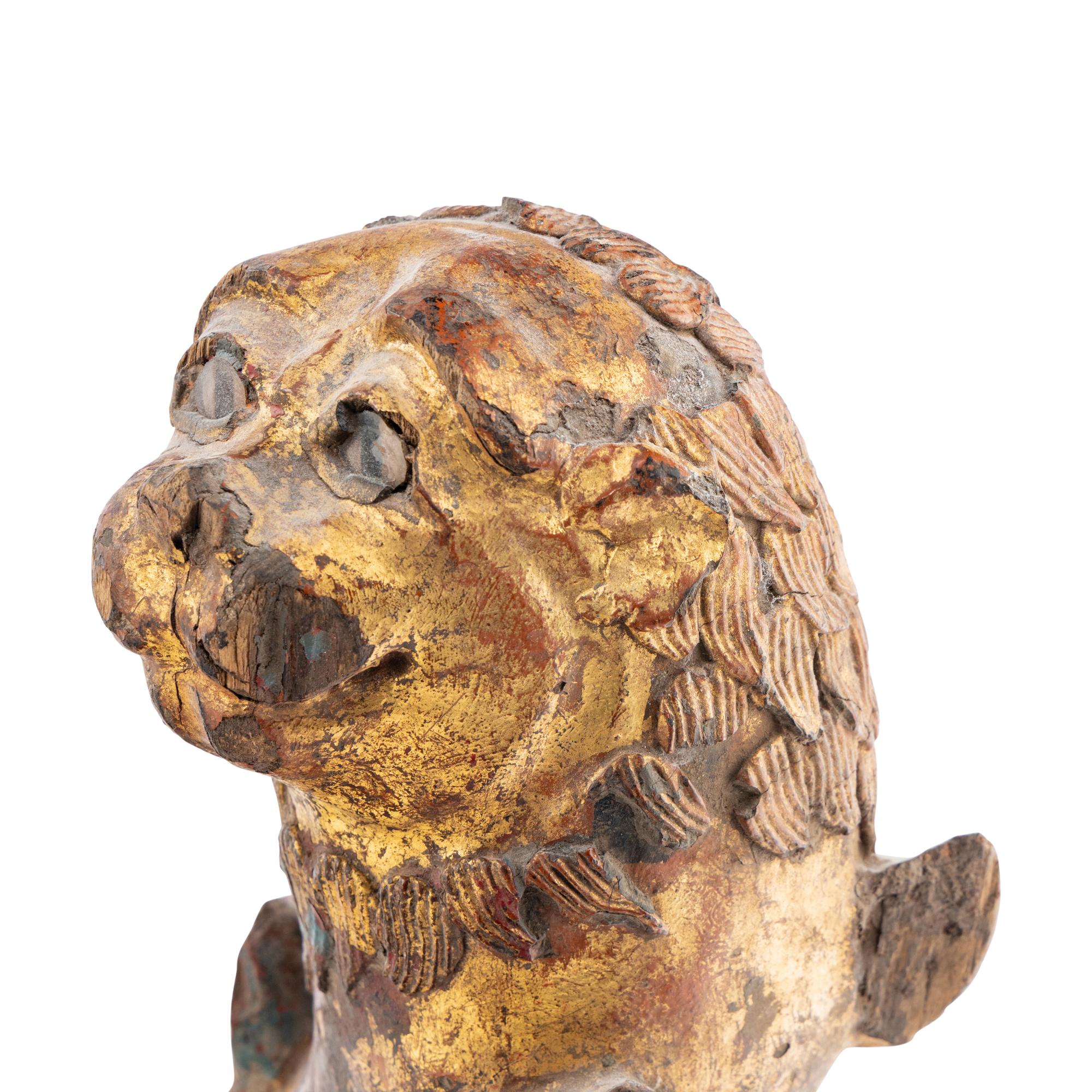 A Pair of Parcel-Gilt and Polychrome Decorated Lion-Form Crest Supporters