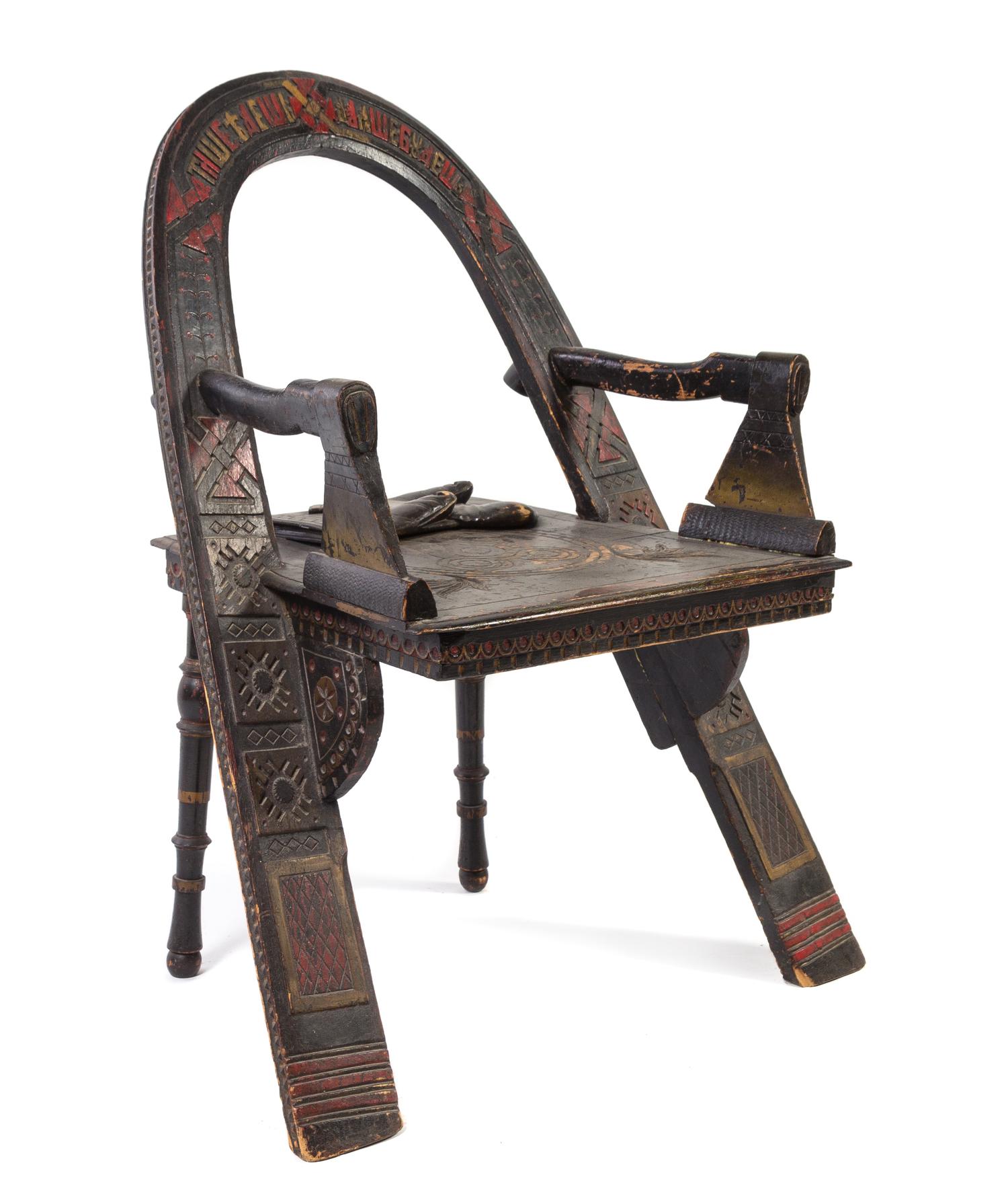 After Vasili Petrovich Shutov, RUSSIA, a Trompe L'Oeil armchair having an arched back with inscriptions, axe arm supports and splayed l