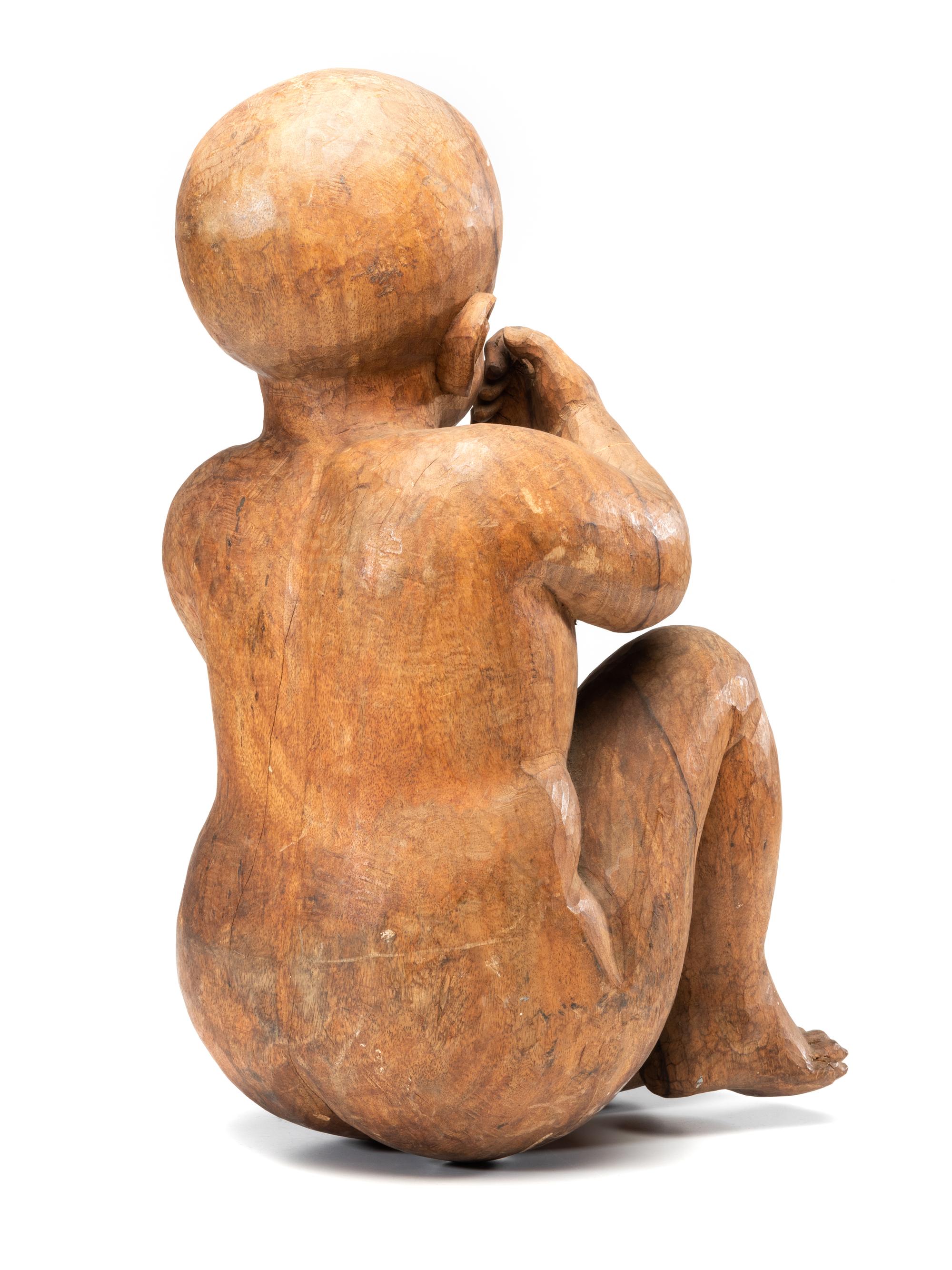 A Carved Wooden Sculpture of a Sleeping Baby