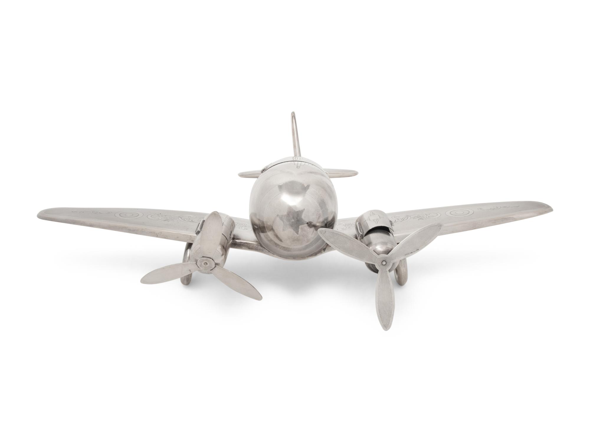 A Large Silvered Metal Airplane-Form Table Top Smoking Set