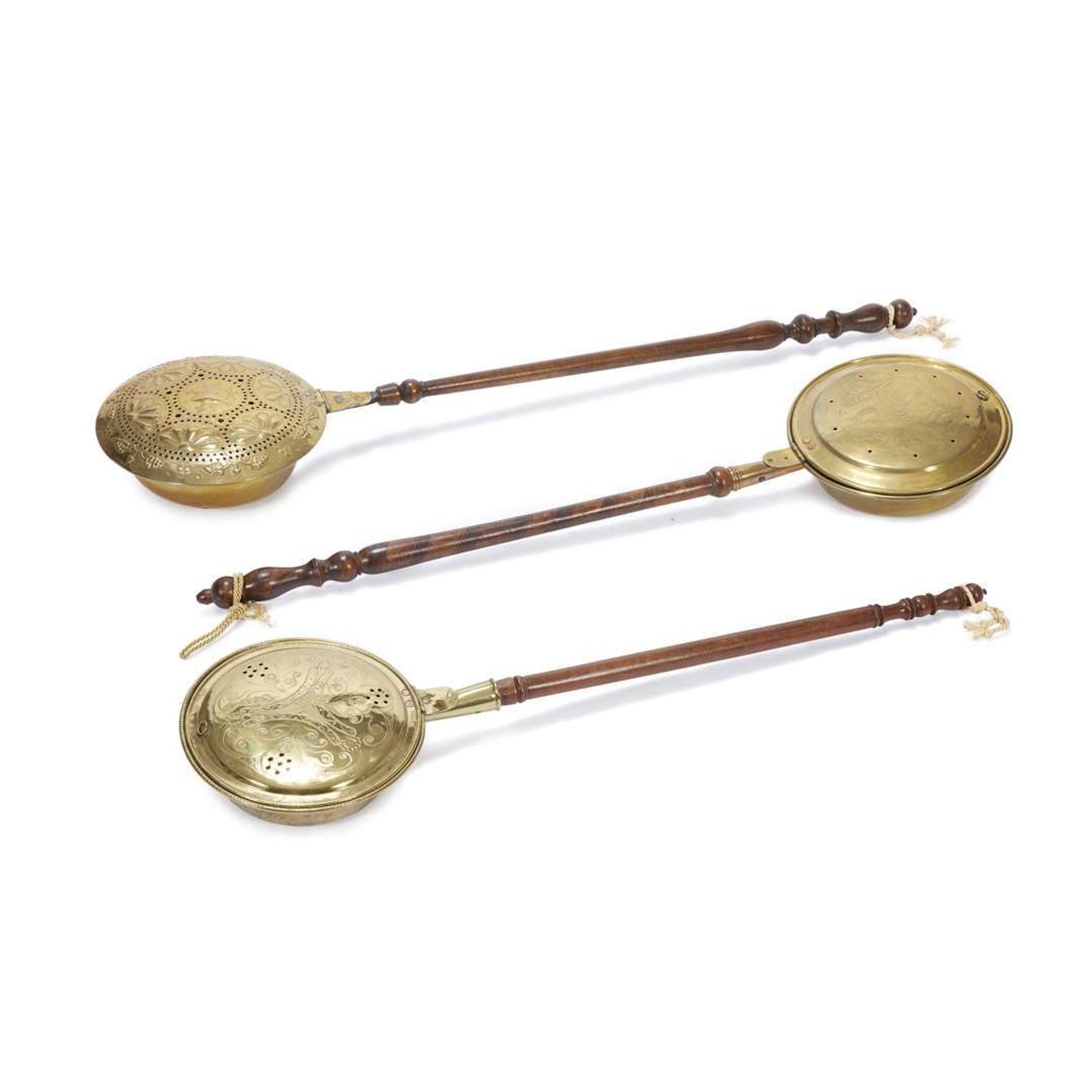 Group of three pierced and decorated brass and turned wood bed warmers 17th-19th century