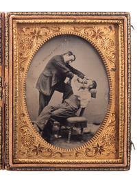 [EARLY PHOTOGRAPHY]. Sixth plate occupational tintype of two friends in a humorous pose, pretending to extract a tooth.