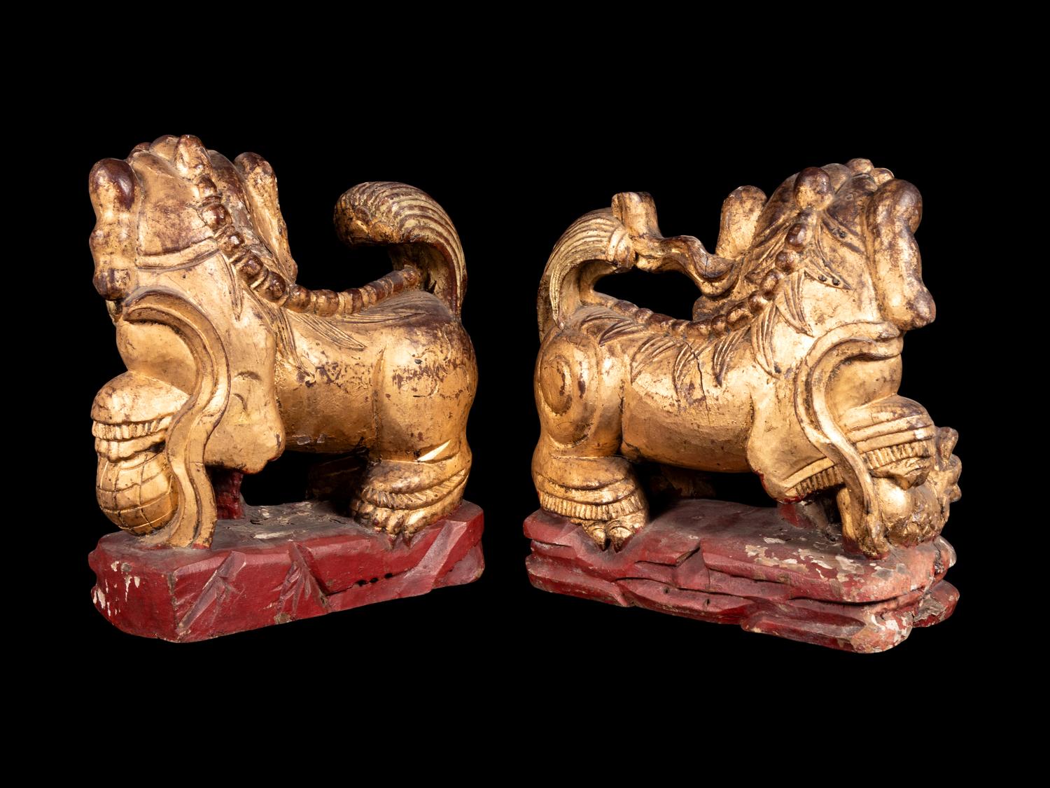 A Pair of Chinese Gilt and Red Lacquered Wood Figures of Fu Lions