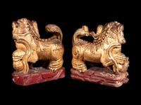 A Pair of Chinese Gilt and Red Lacquered Wood Figures of Fu Lions
