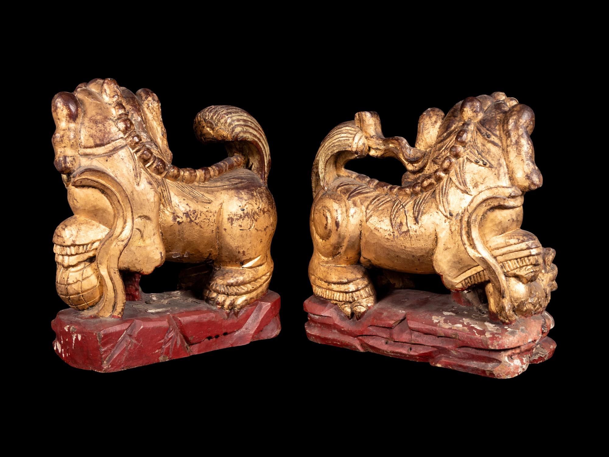 A Pair of Chinese Gilt and Red Lacquered Wood Figures of Fu Lions