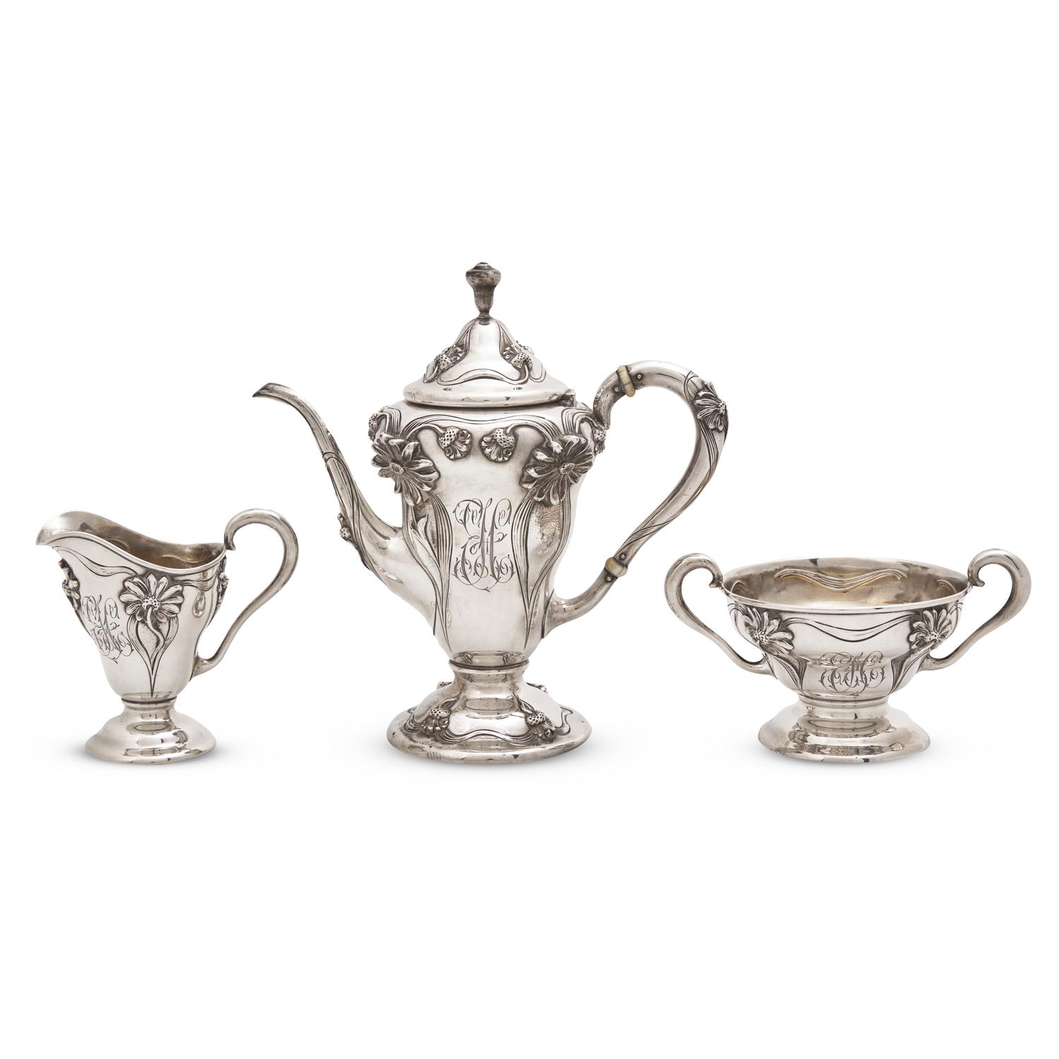 An Art Nouveau Three-Piece Sterling Silver Floral Cast and Repousse Coffee Service