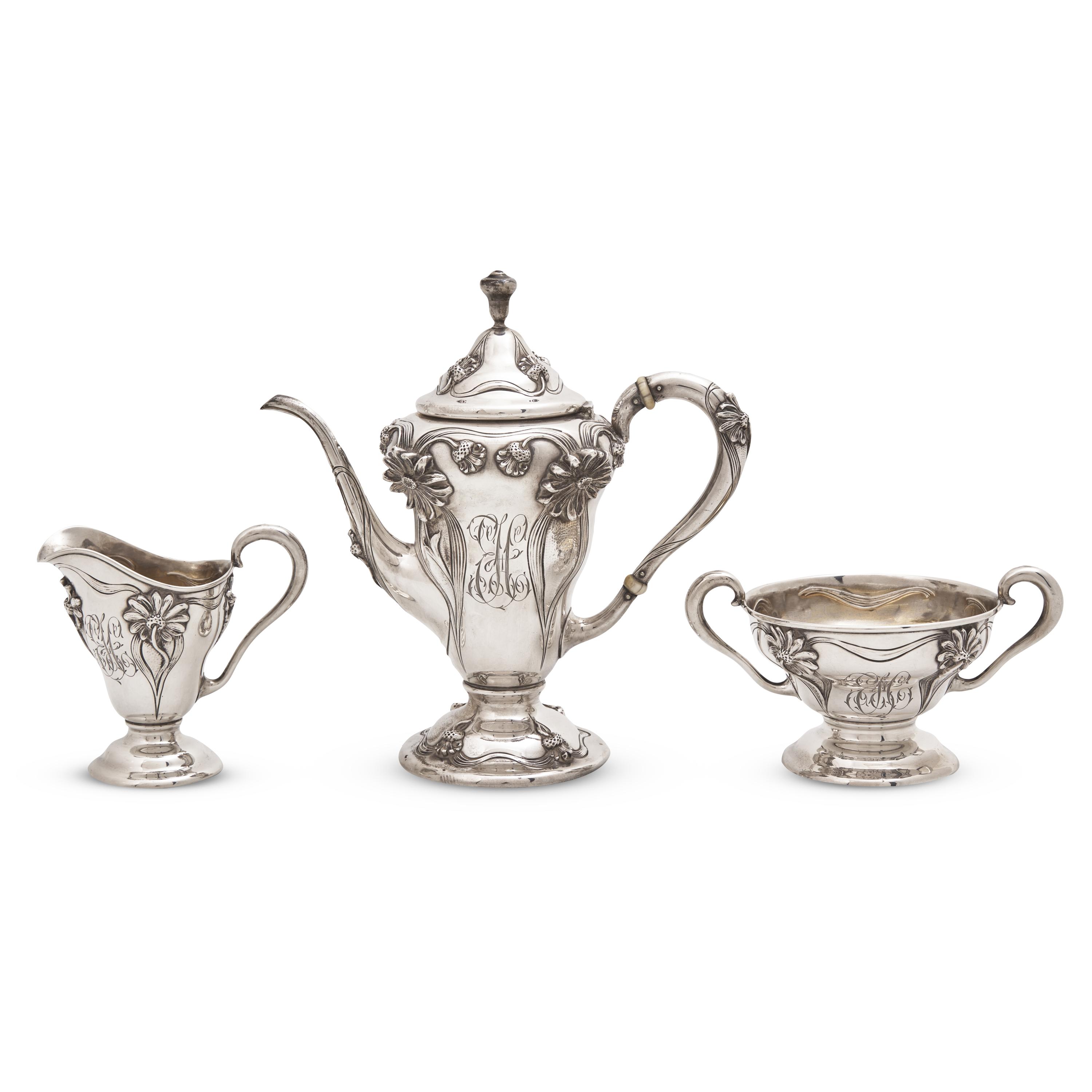 An Art Nouveau Three-Piece Sterling Silver Floral Cast and Repousse Coffee Service