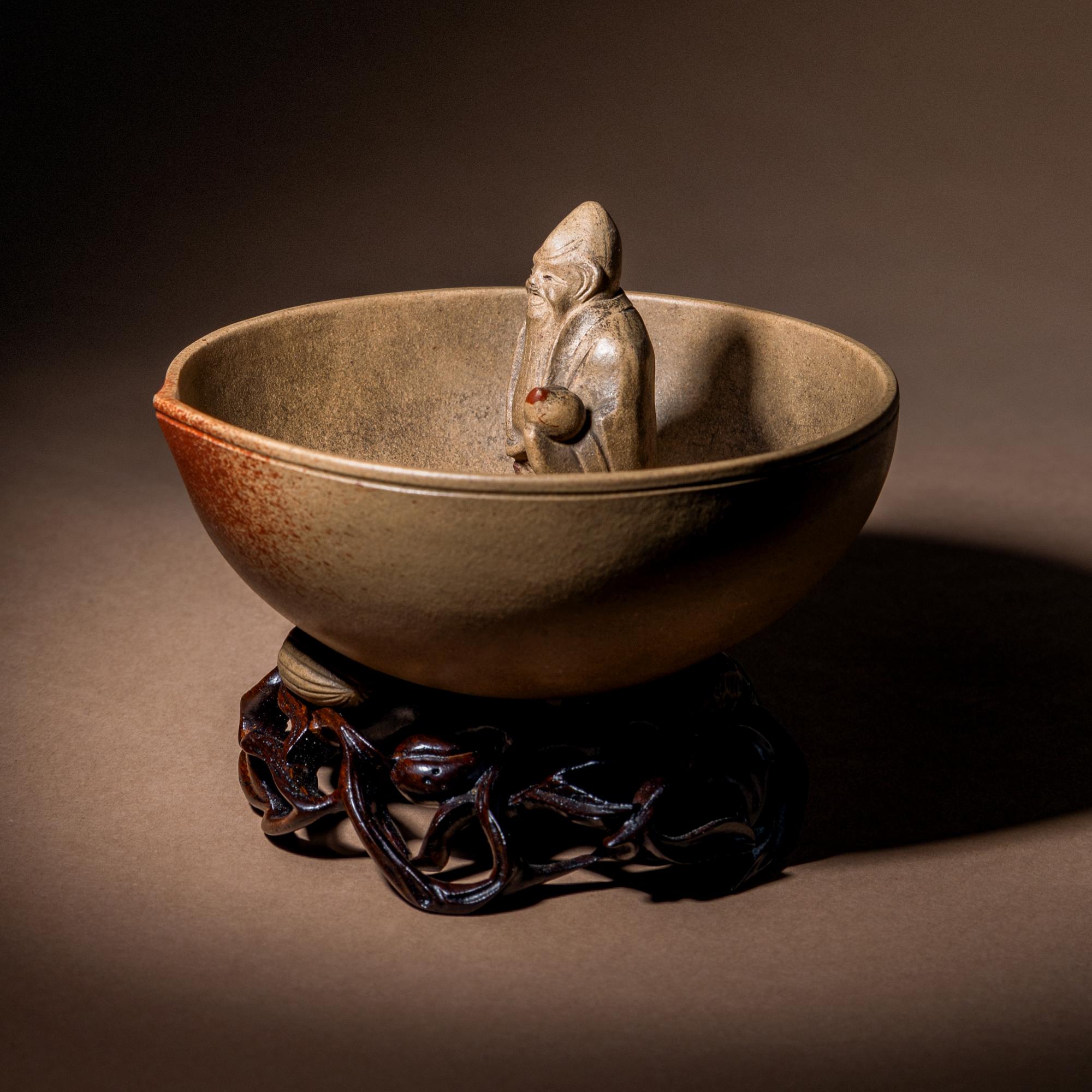 A Rare Yixing Peach-Form 'Figure' Puzzle Cup with Impressed Seals 'Chen', 'Mingyuan' and Wood Stand 陳鳴遠款醉翁桃形公道杯