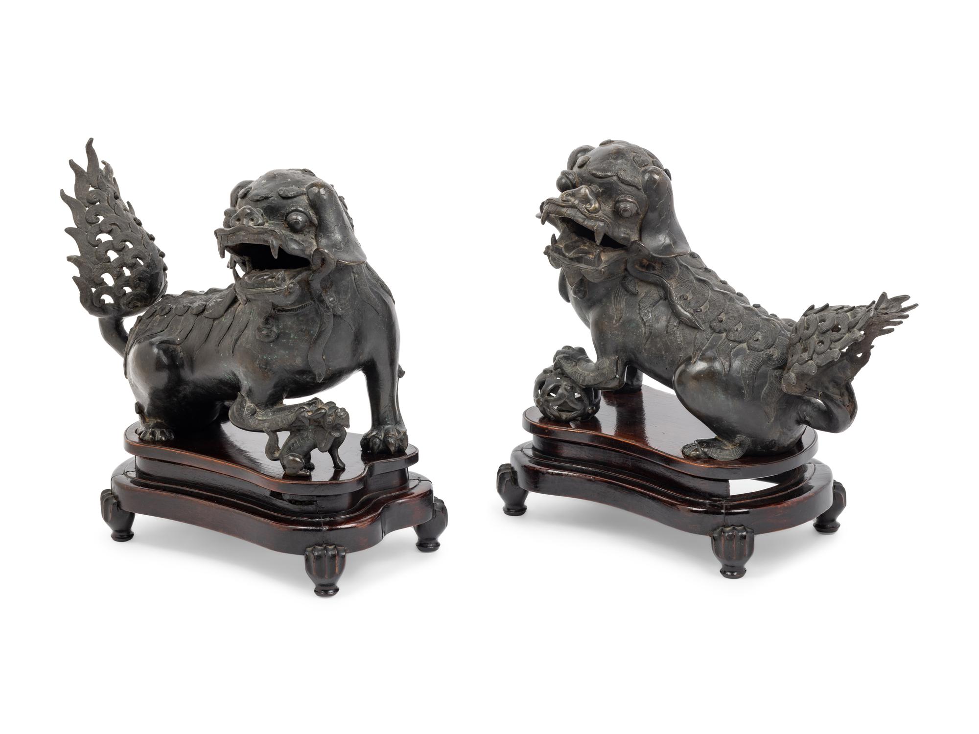 A Pair of Chinese Bronze Buddhistic Lions with Wood Stands