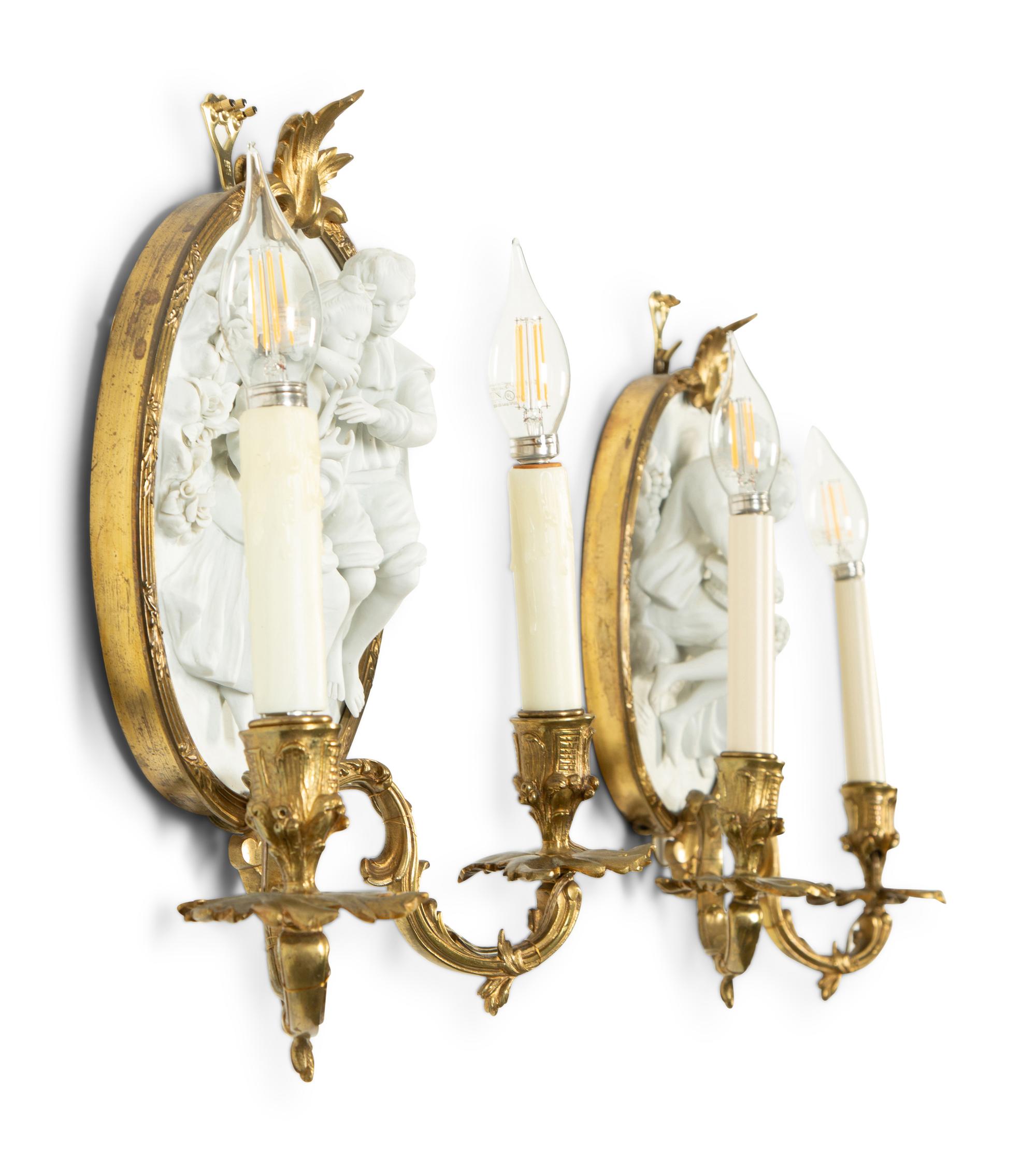 A Pair of Continental Plaster Relief Medallion and Gilt Bronze Two-Light Sconces